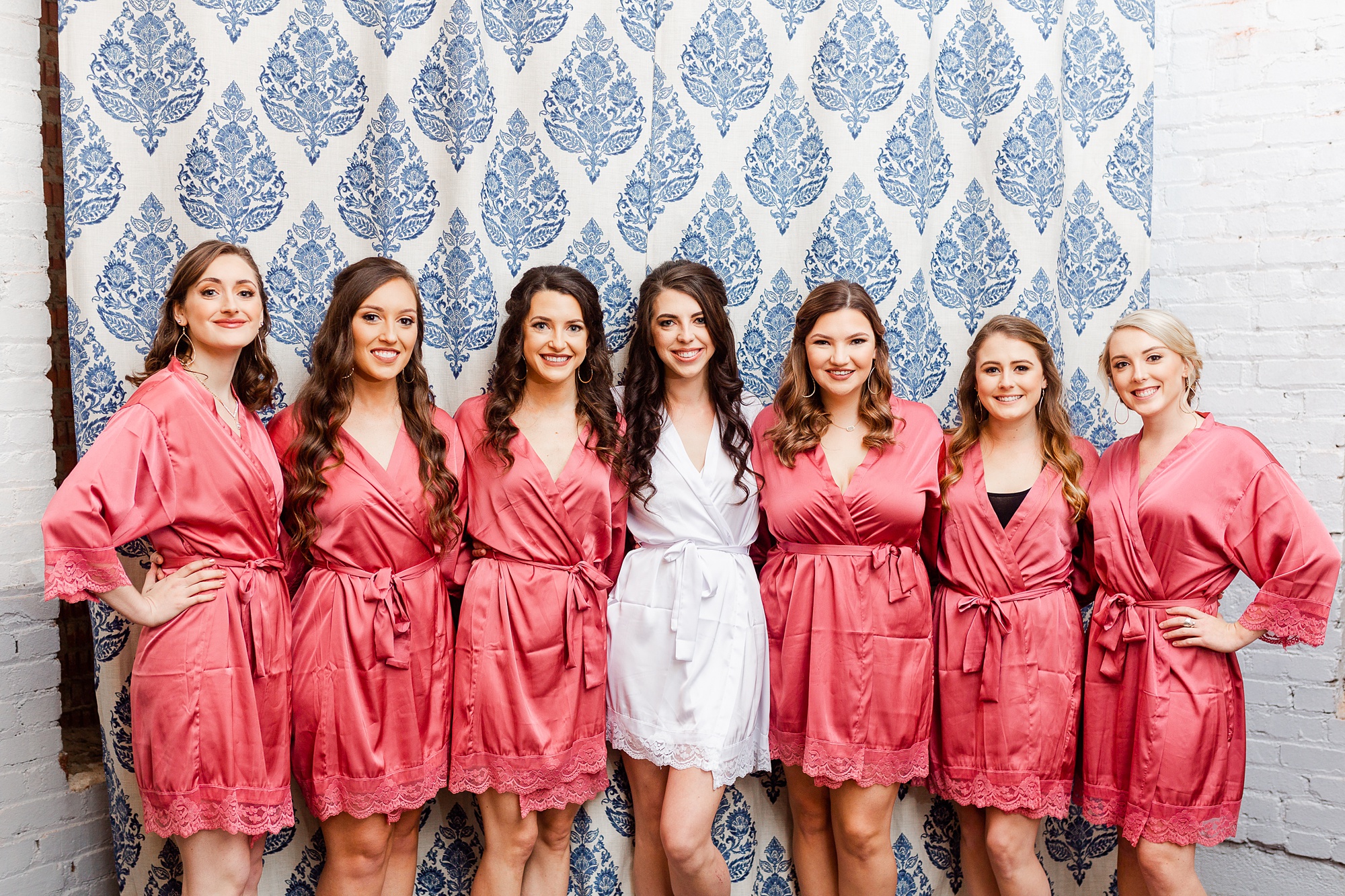 bride poses with bridesmaids in custom matching robes