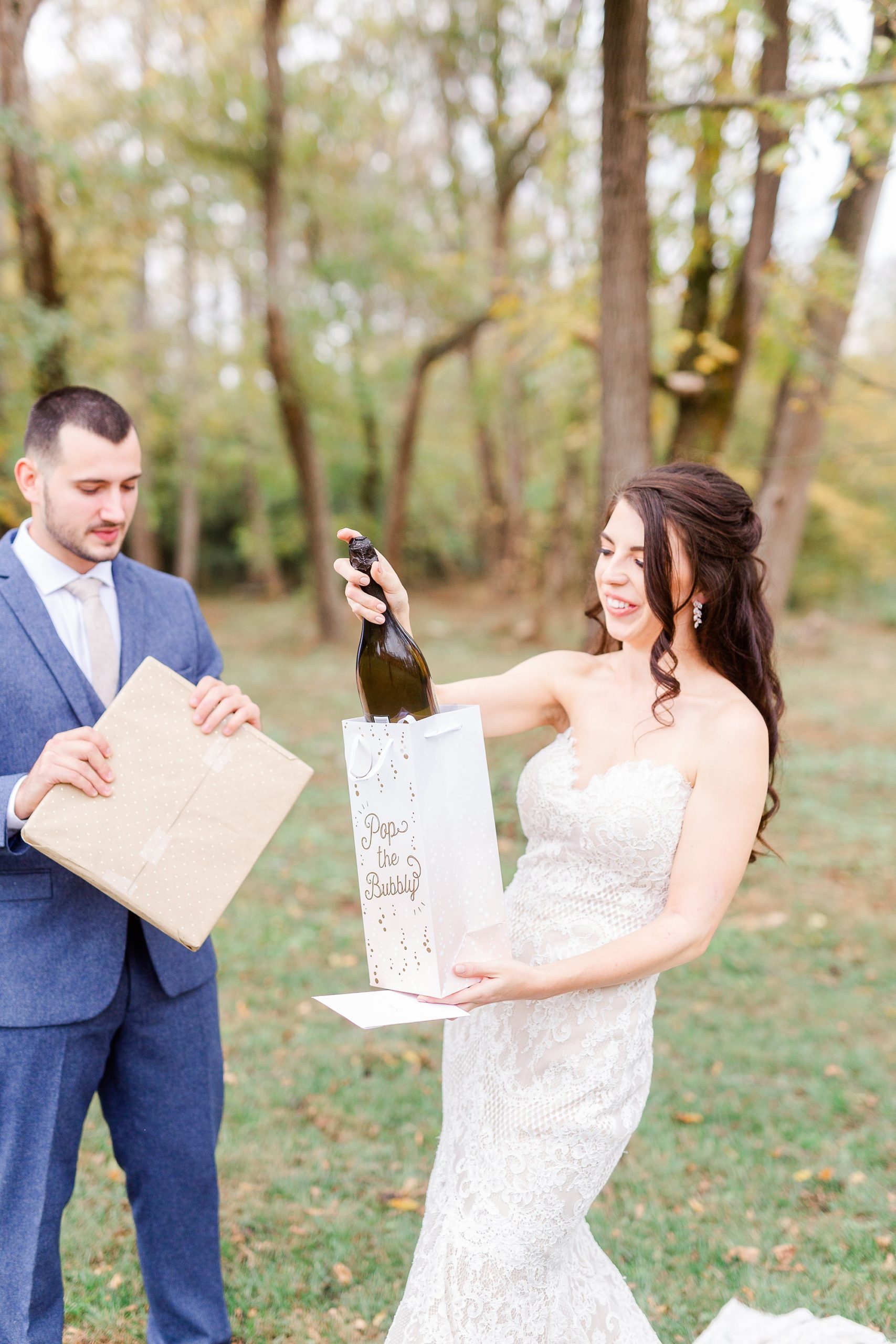bride opens bottle of champagne from groom