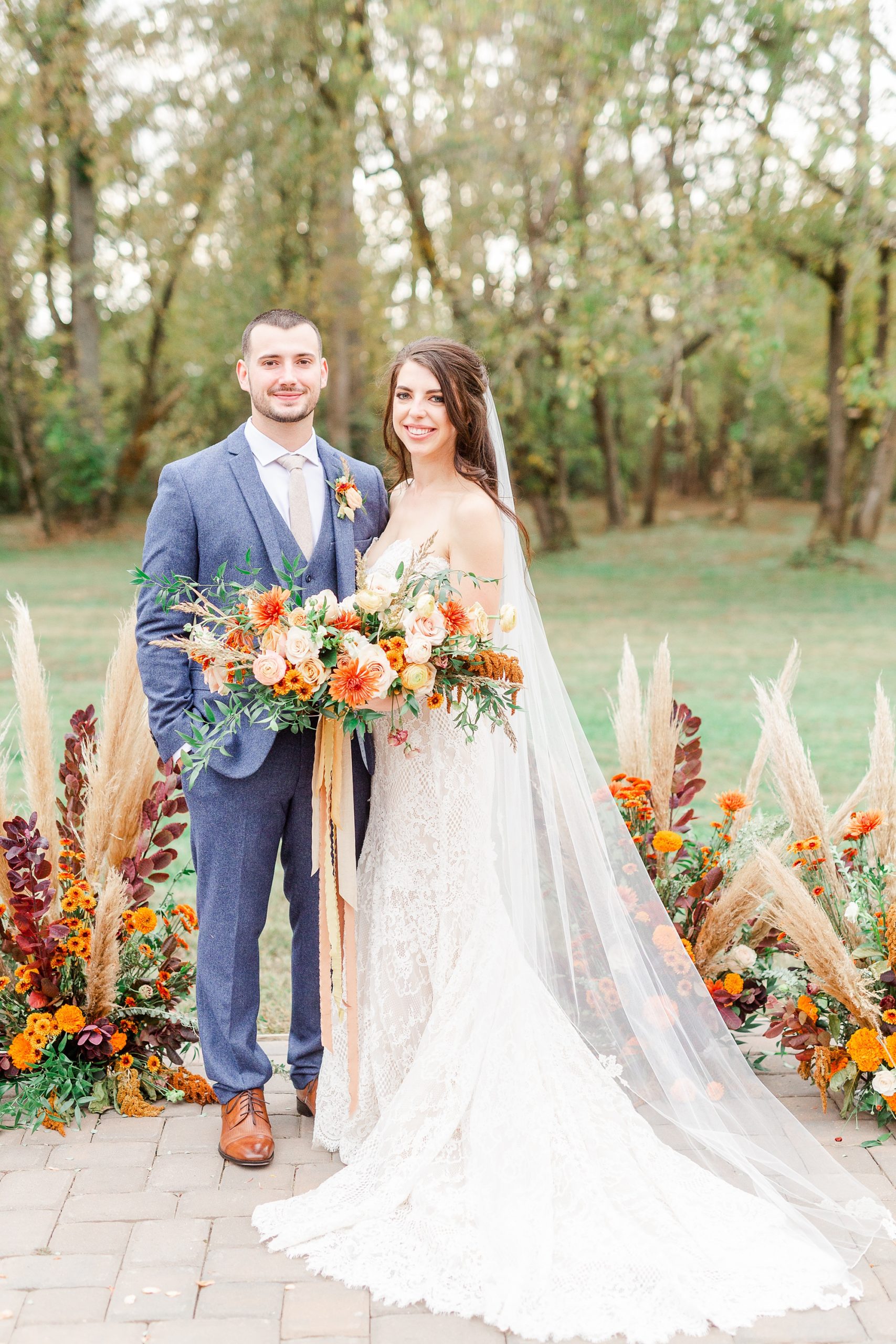 bride and groom pose by boho wedding florals at Providence Cotton Mill