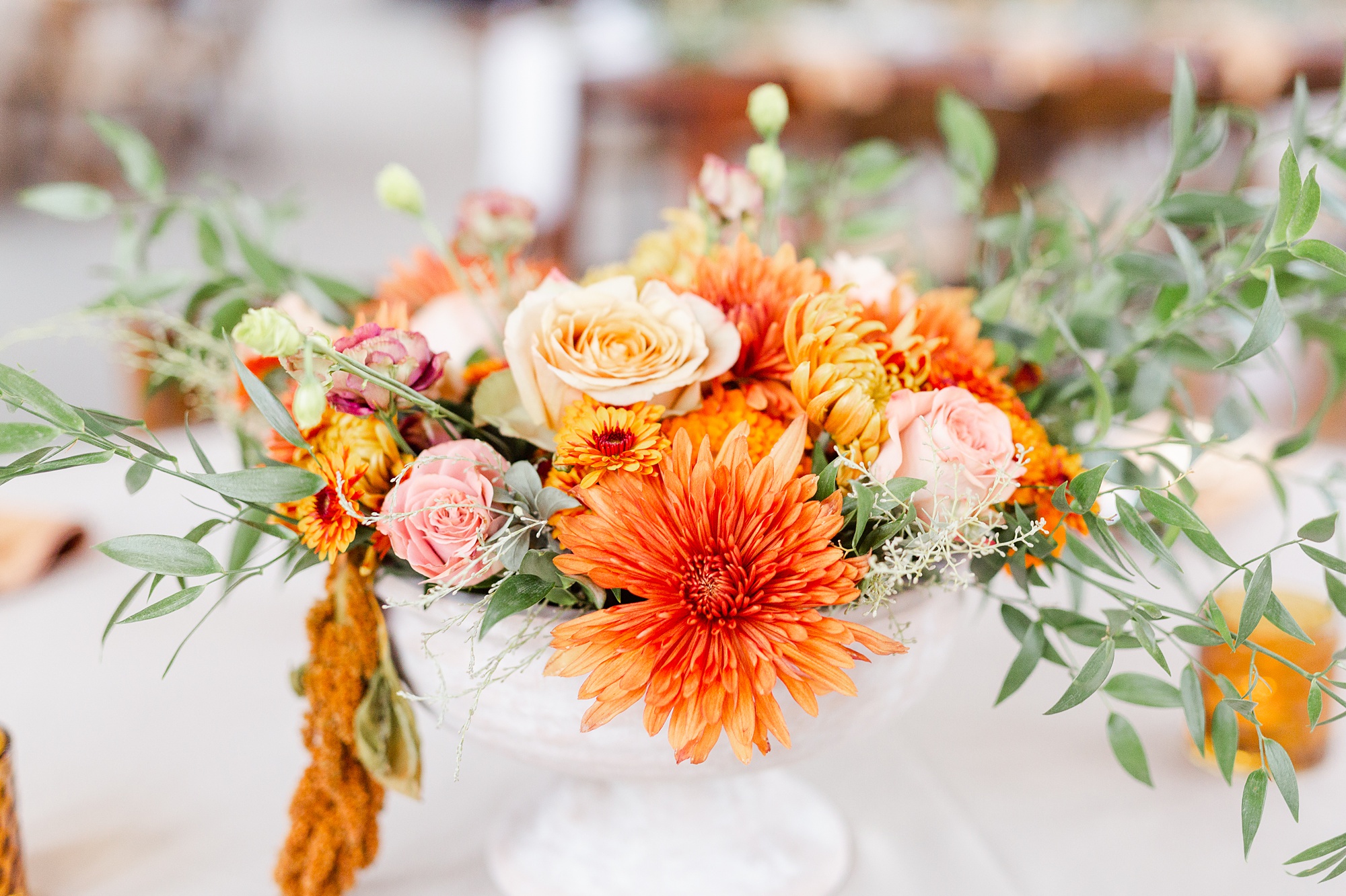 orange florals sit in white bowl on table for Providence Cotton Mill wedding reception