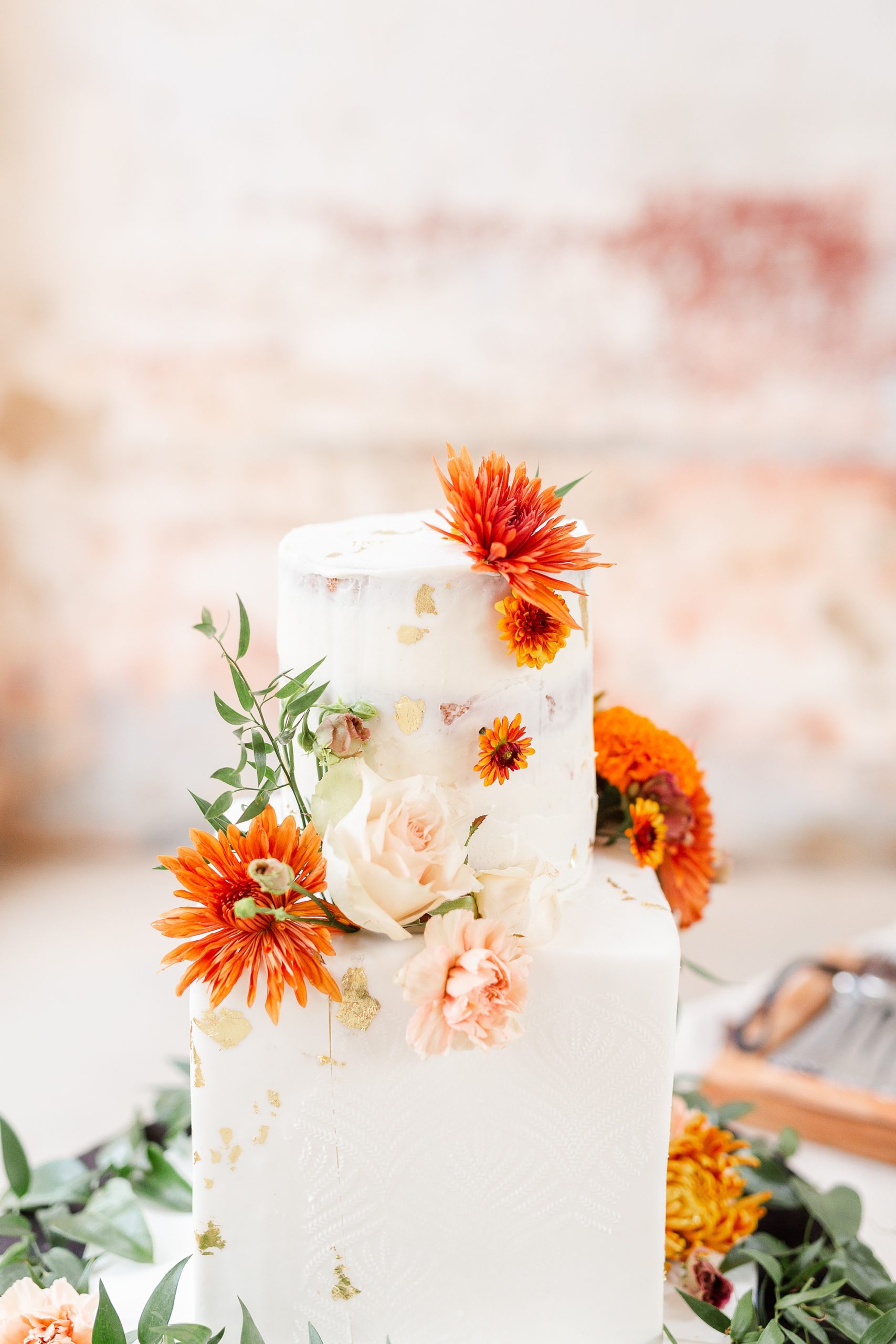 fall wedding cake with orange floral accents