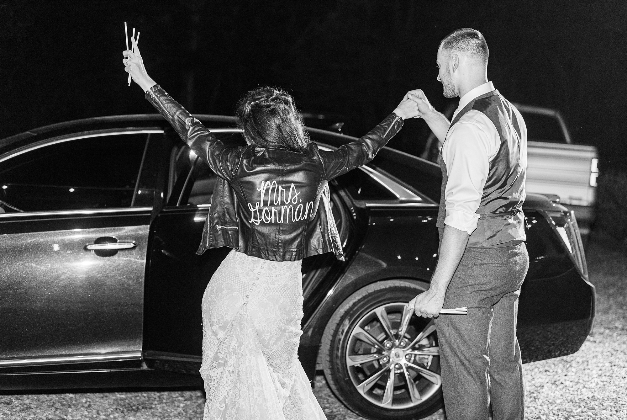 bride shows off custom leather jacket during NC wedding exit