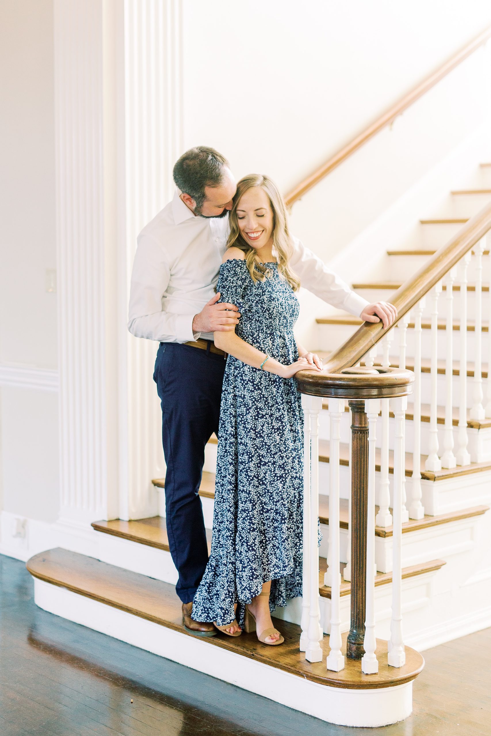 engaged couple poses on staircase in Separk Mansion