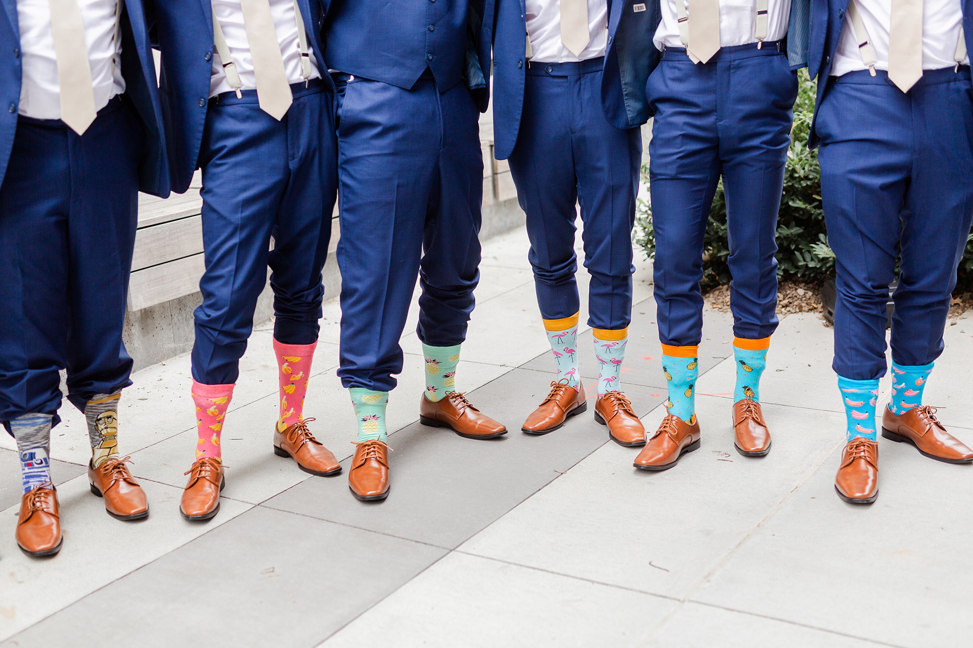 groomsmen show off funny socks on wedding day with pants tucked into socks
