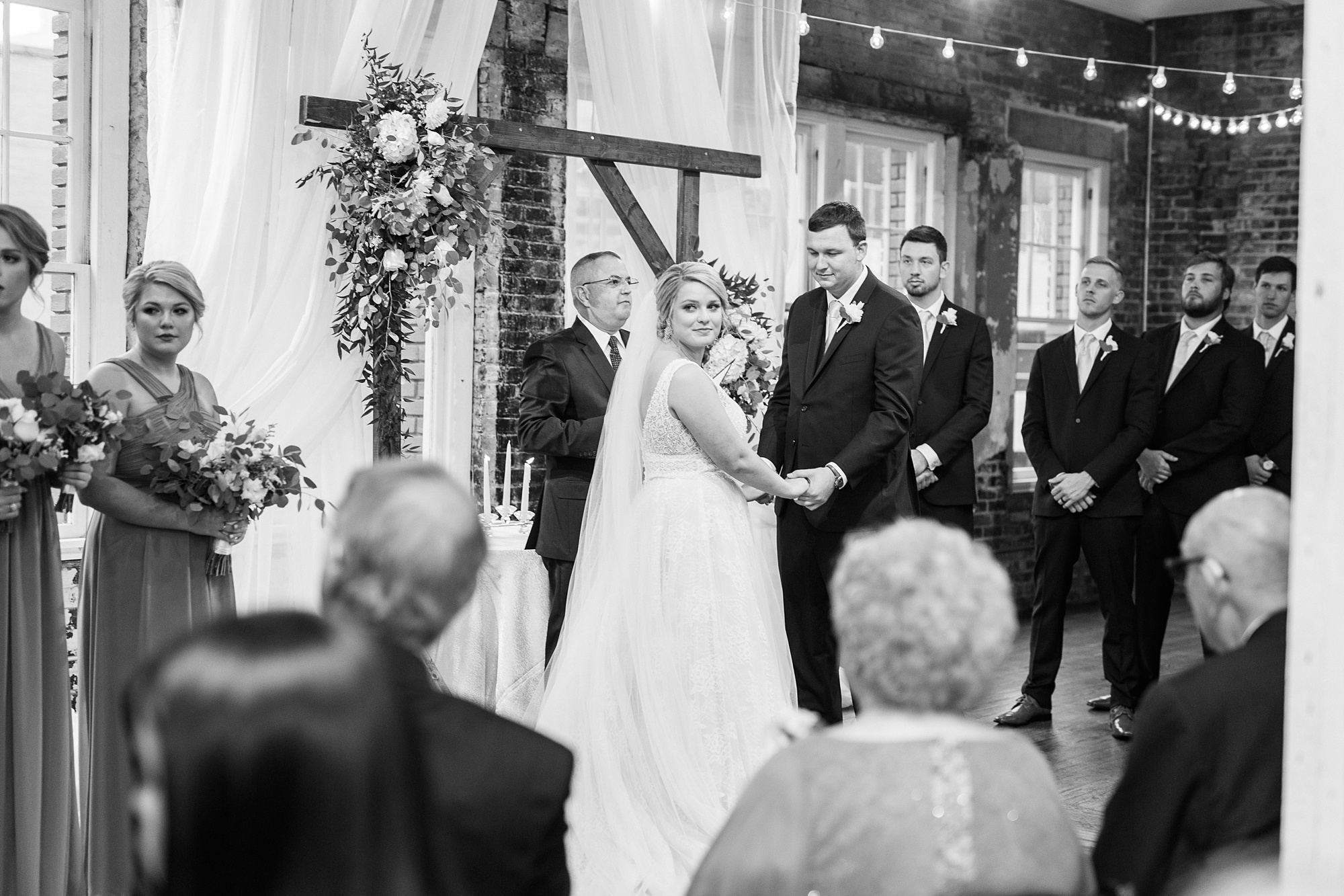 bride and groom look back at parents during wedding ceremony at Stockroom at 230