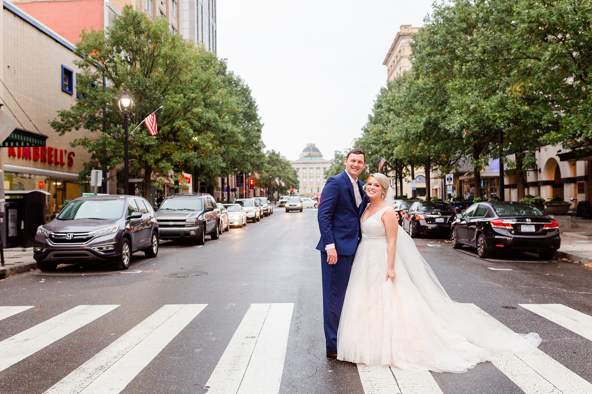 bride and groom walk across crosswalk in Raleigh NC