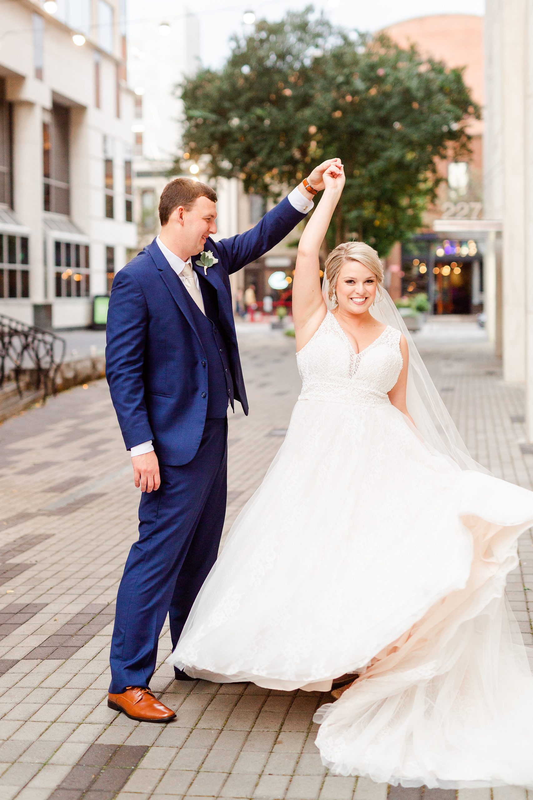 groom twirls bride on street of Raleigh NC