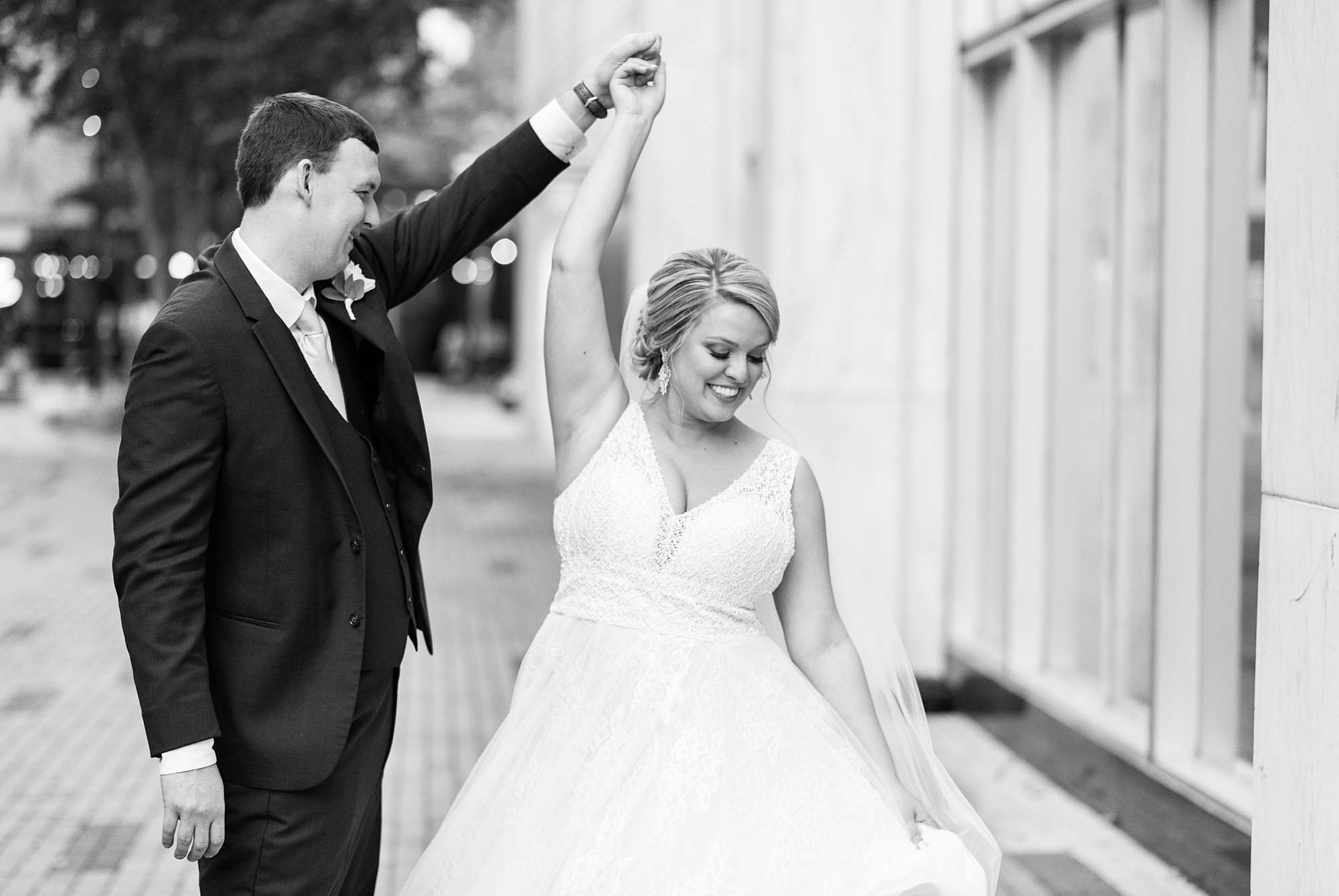 groom twirls bride during NC wedding photos