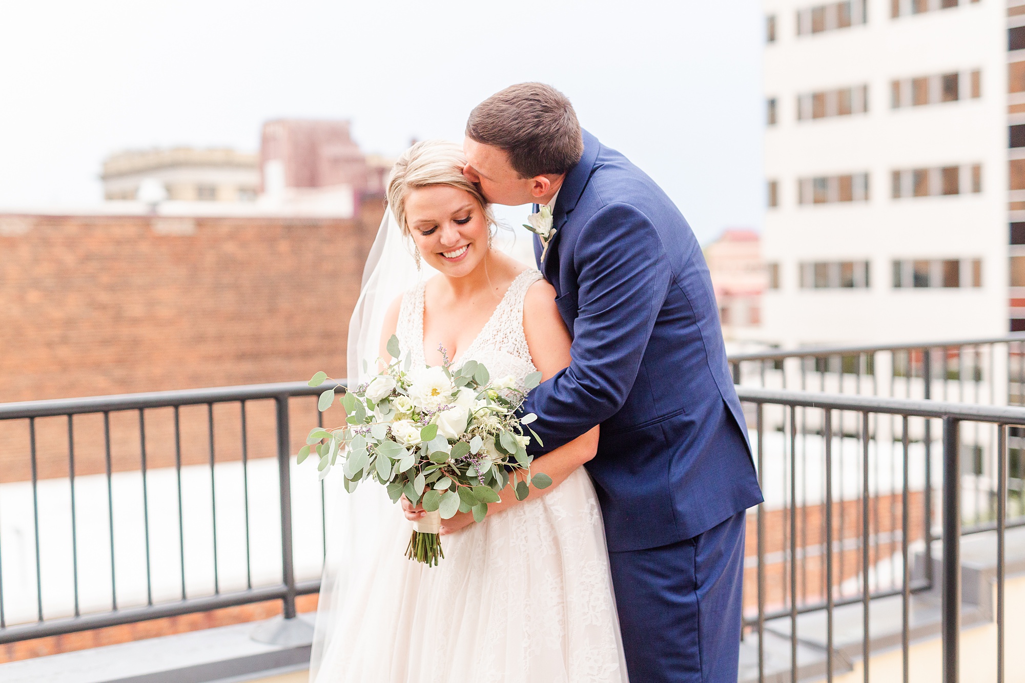 groom kisses bride's head during Stockroom at 230 wedding photos