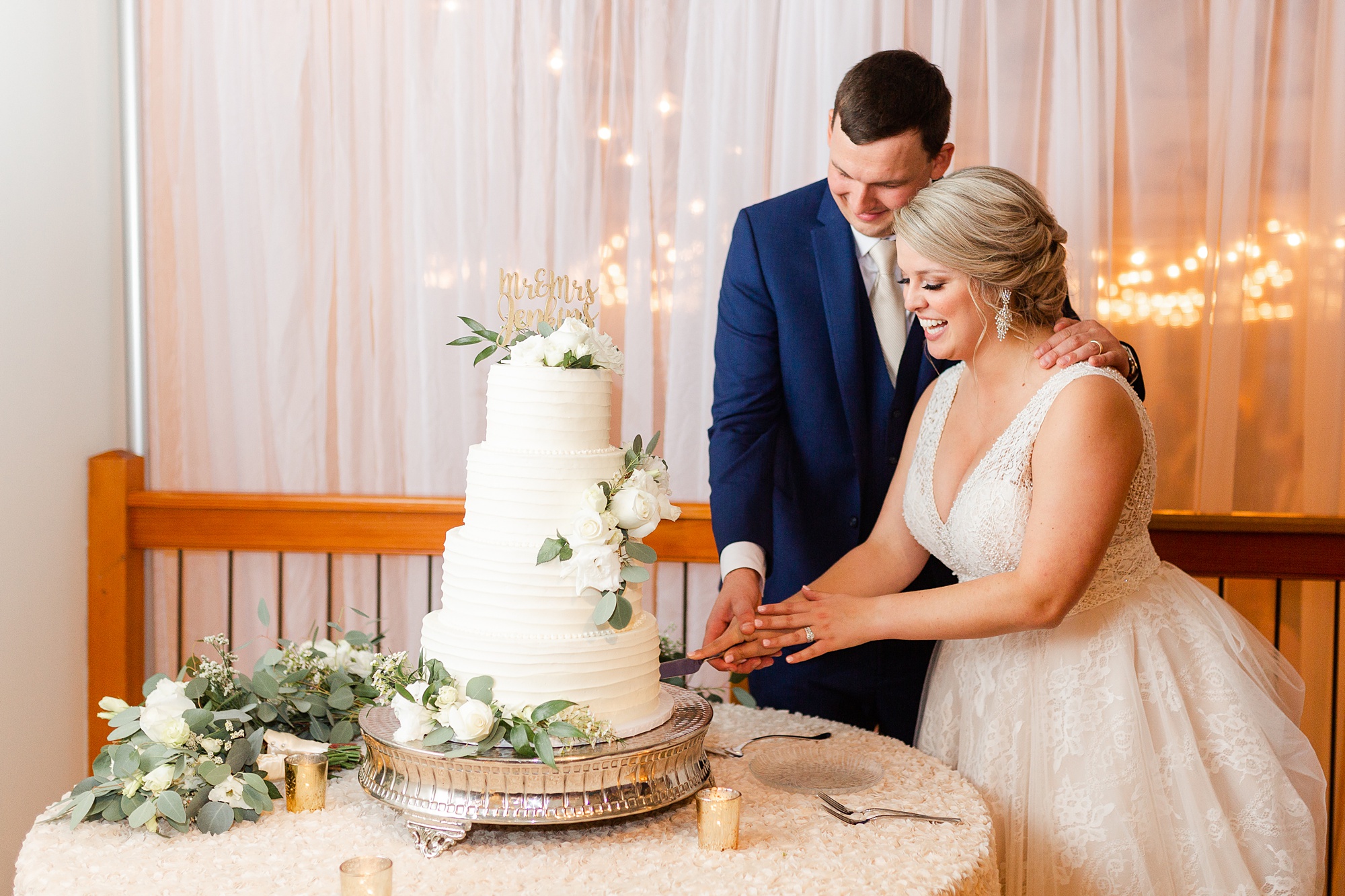 bride and groom cut wedding cake during Raleigh NC wedding reception