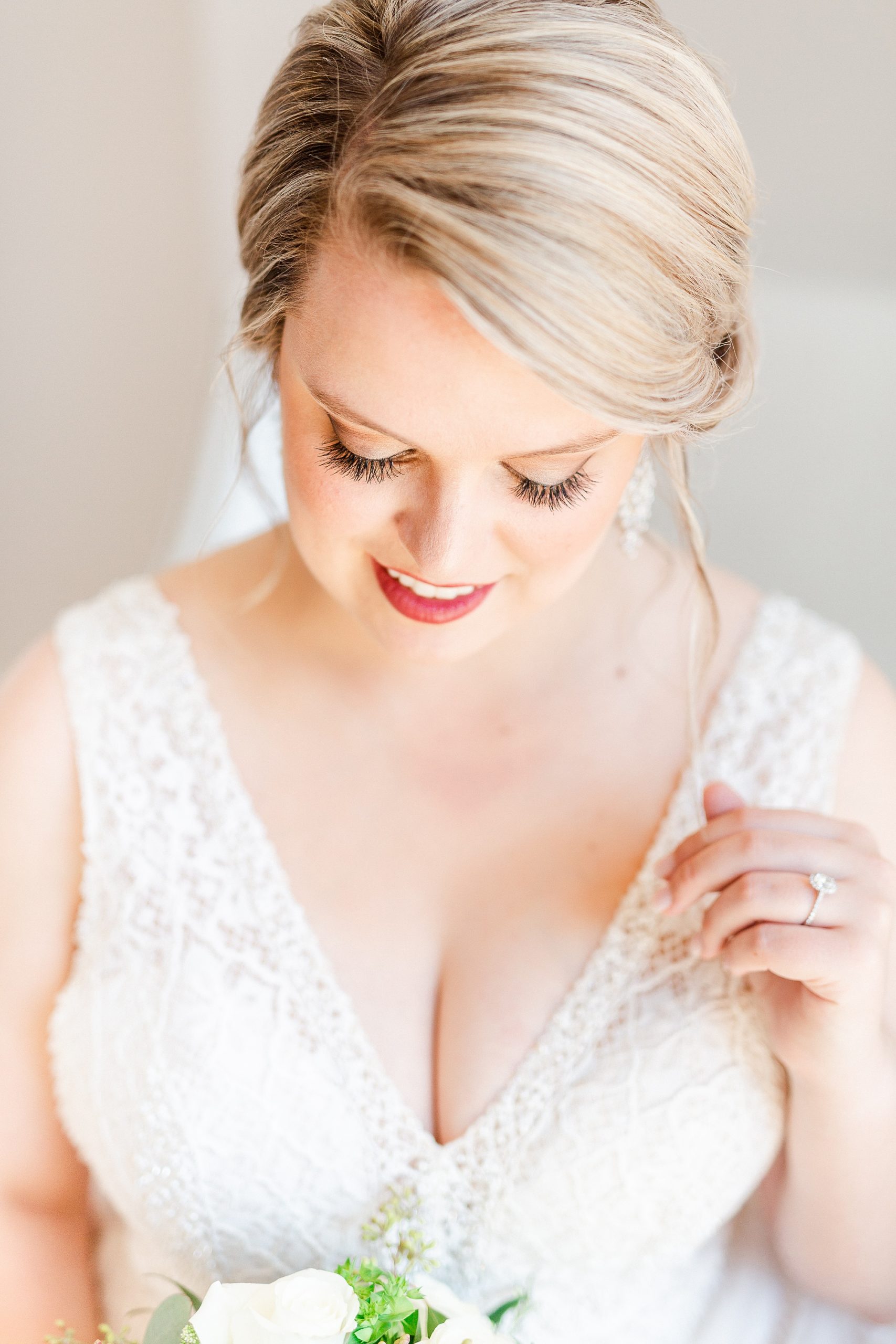bride holds strand of hair during bridal portraits