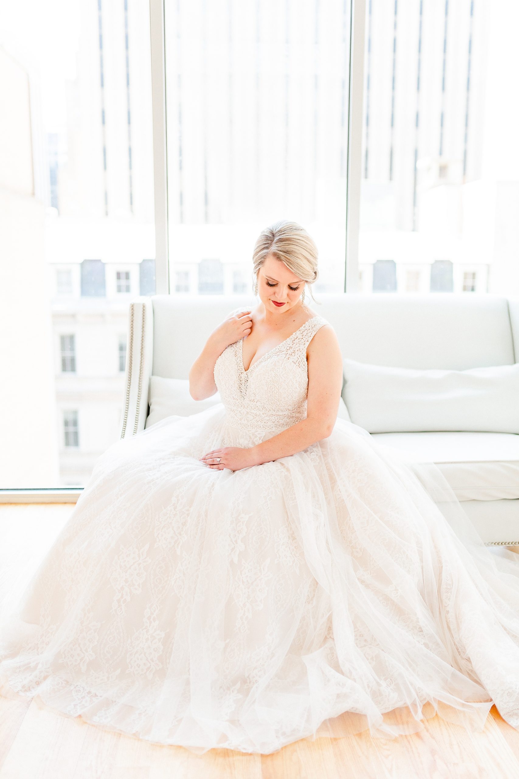 bride sits on couch in The Glass Box during bridal session