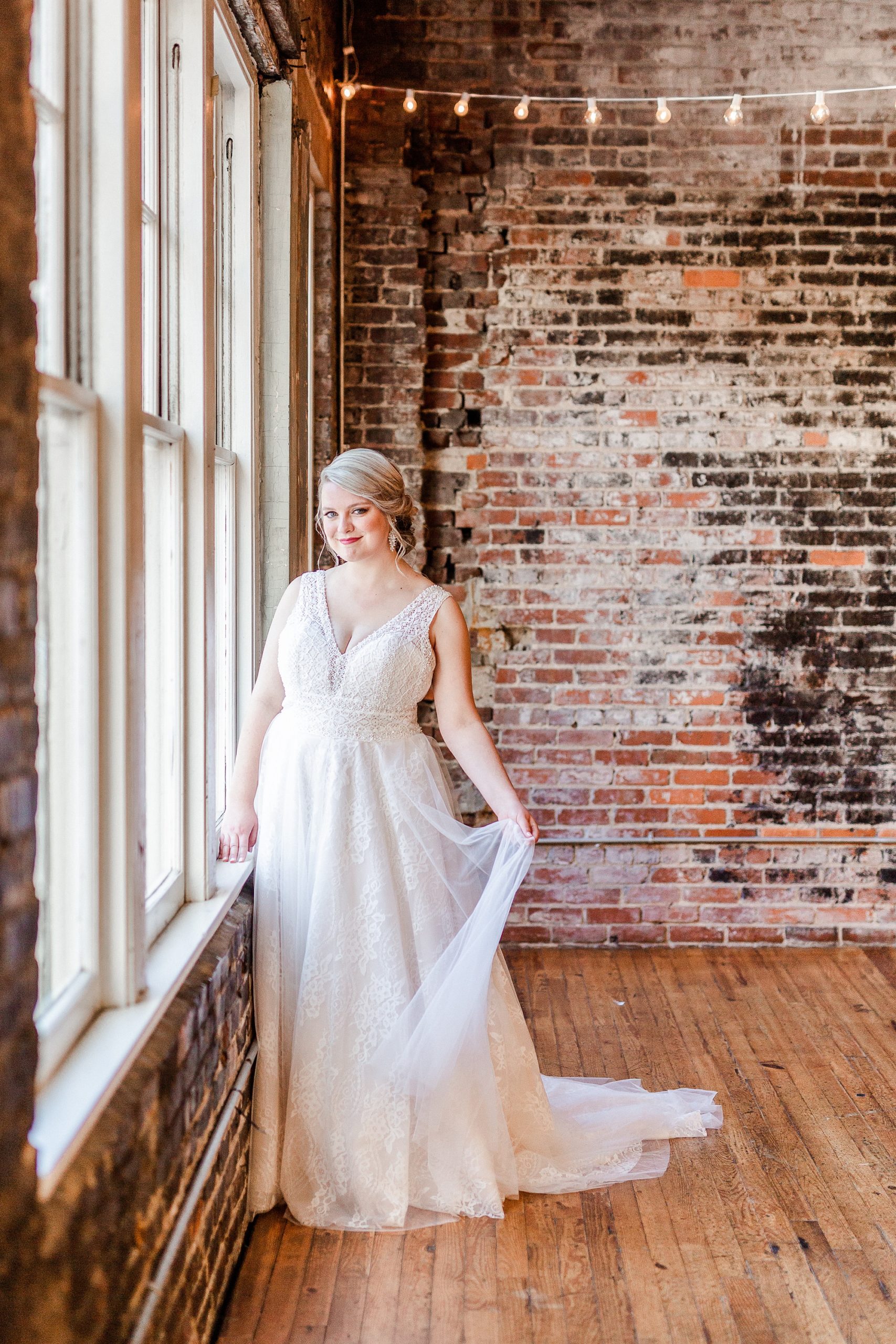 bride poses by brick wall in The Stockroom at 230