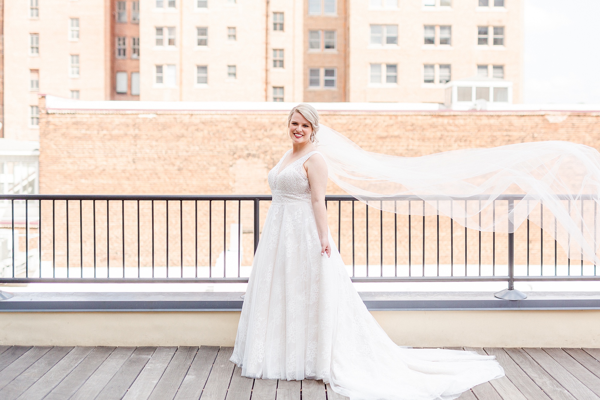 bride poses on balcony at The Glass Box