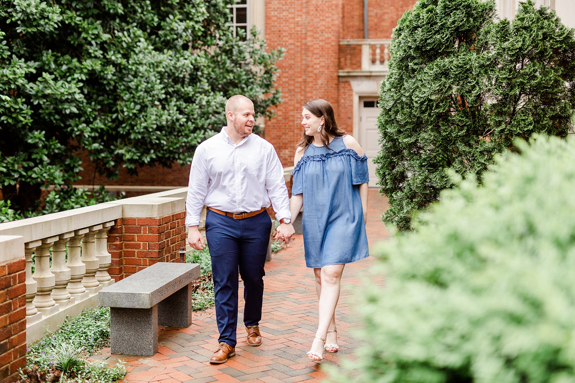 couple holds hands and walks through Davidson NC