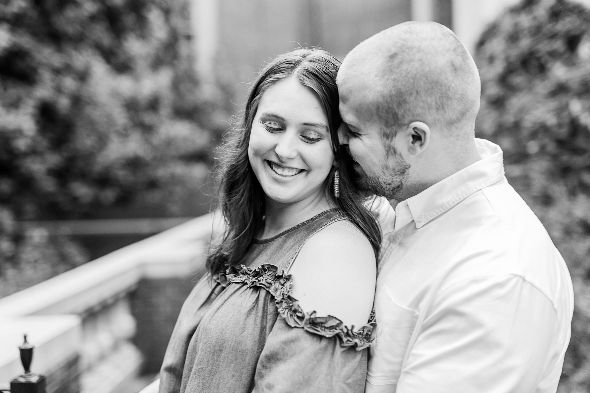 groom makes bride laugh during Downtown Davidson engagement photos