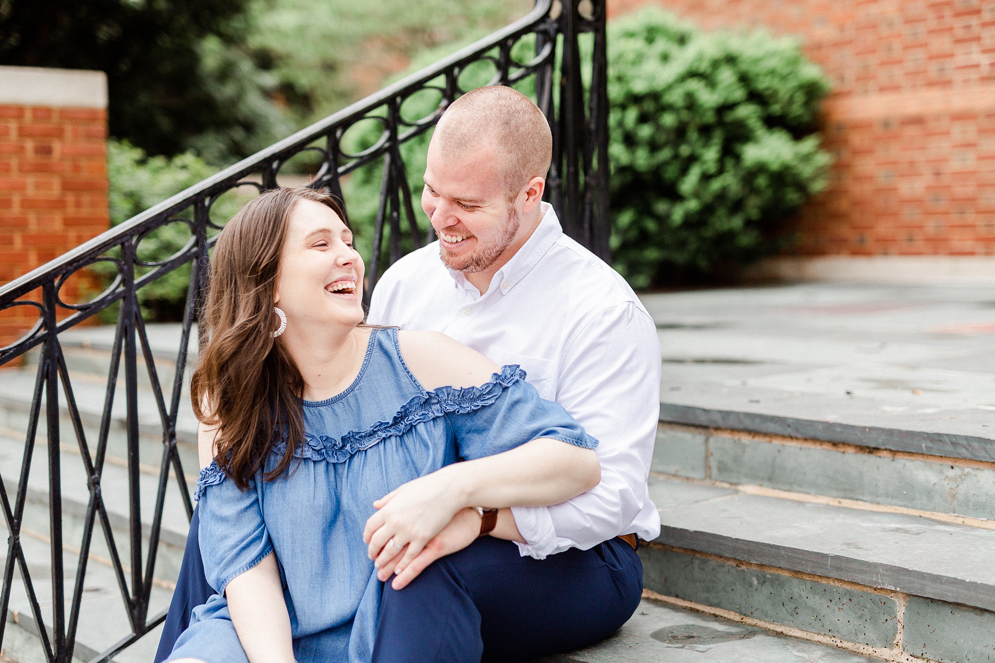 bride laughs with groom during portraits on steps in Downtown Davidson