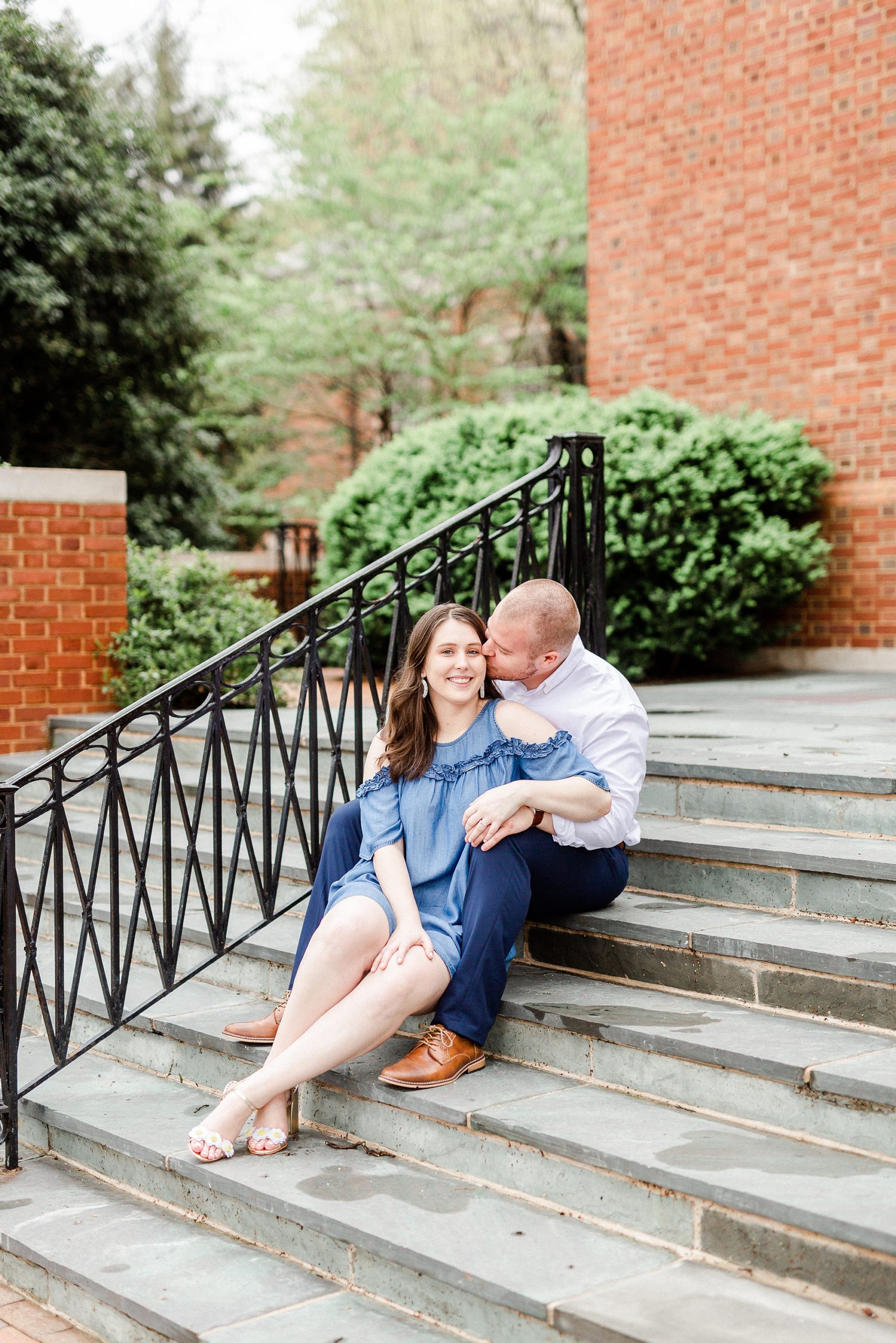 bride and groom sit on steps of building in Downtown Davidson