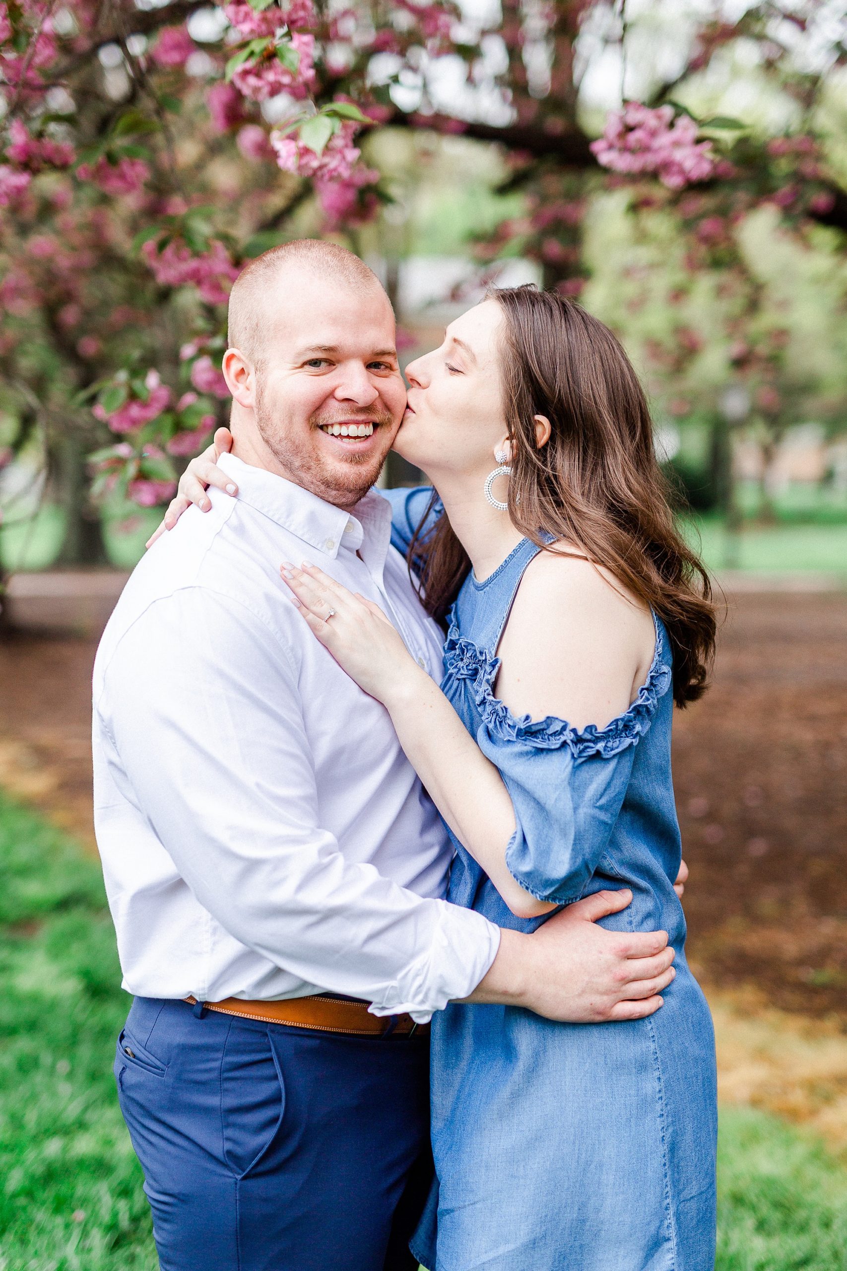 bride kisses fiance during springtime engagement photos