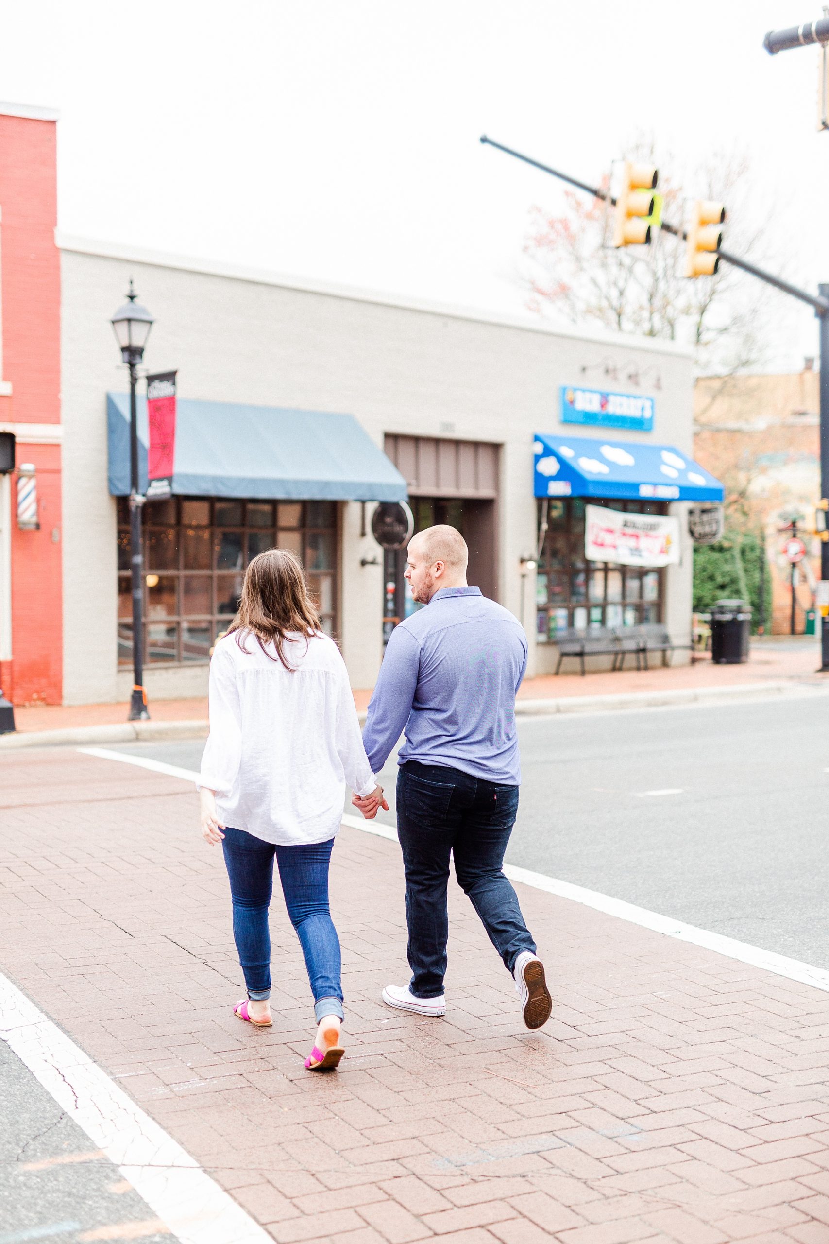 engaged couple walks through street in Downtown Davidson
