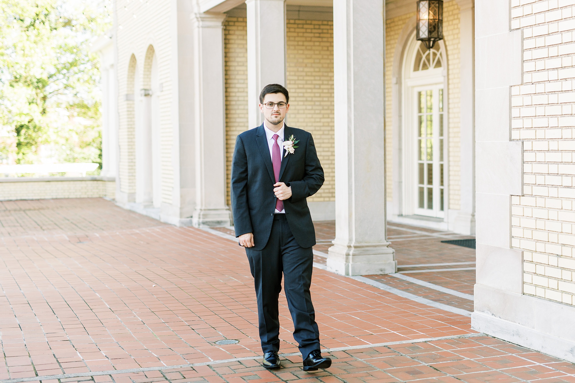groom in navy suit walks on patio at Separk Mansion