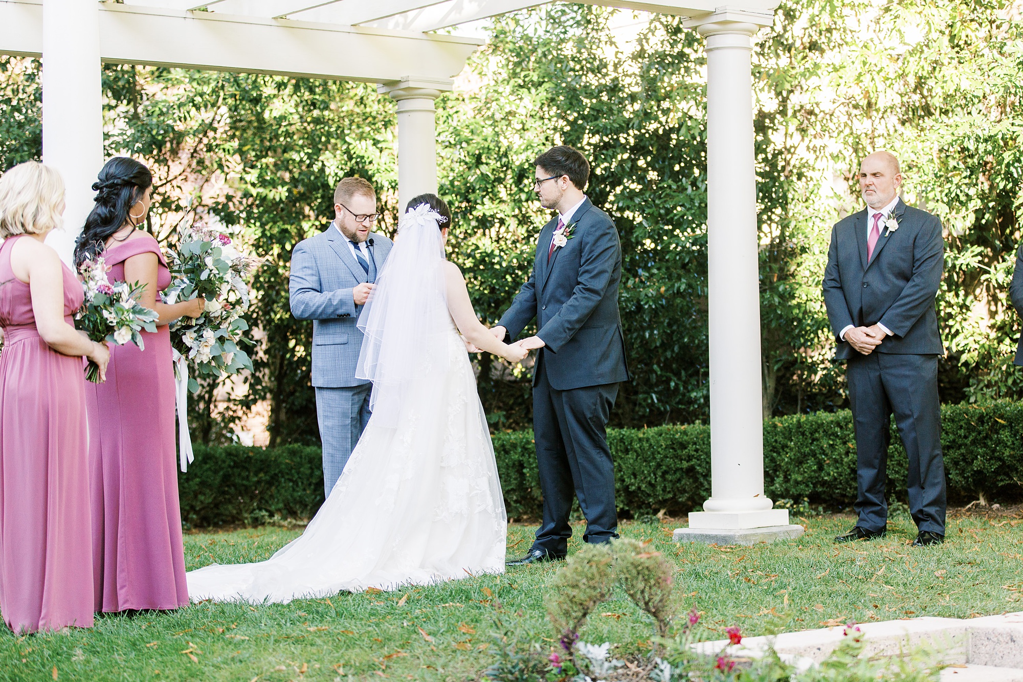 newlyweds exchange vows during outdoor garden ceremony at Separk Mansion