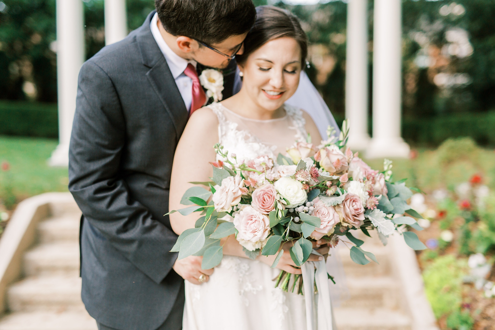 groom leans down to kiss bride during NC wedding portraits