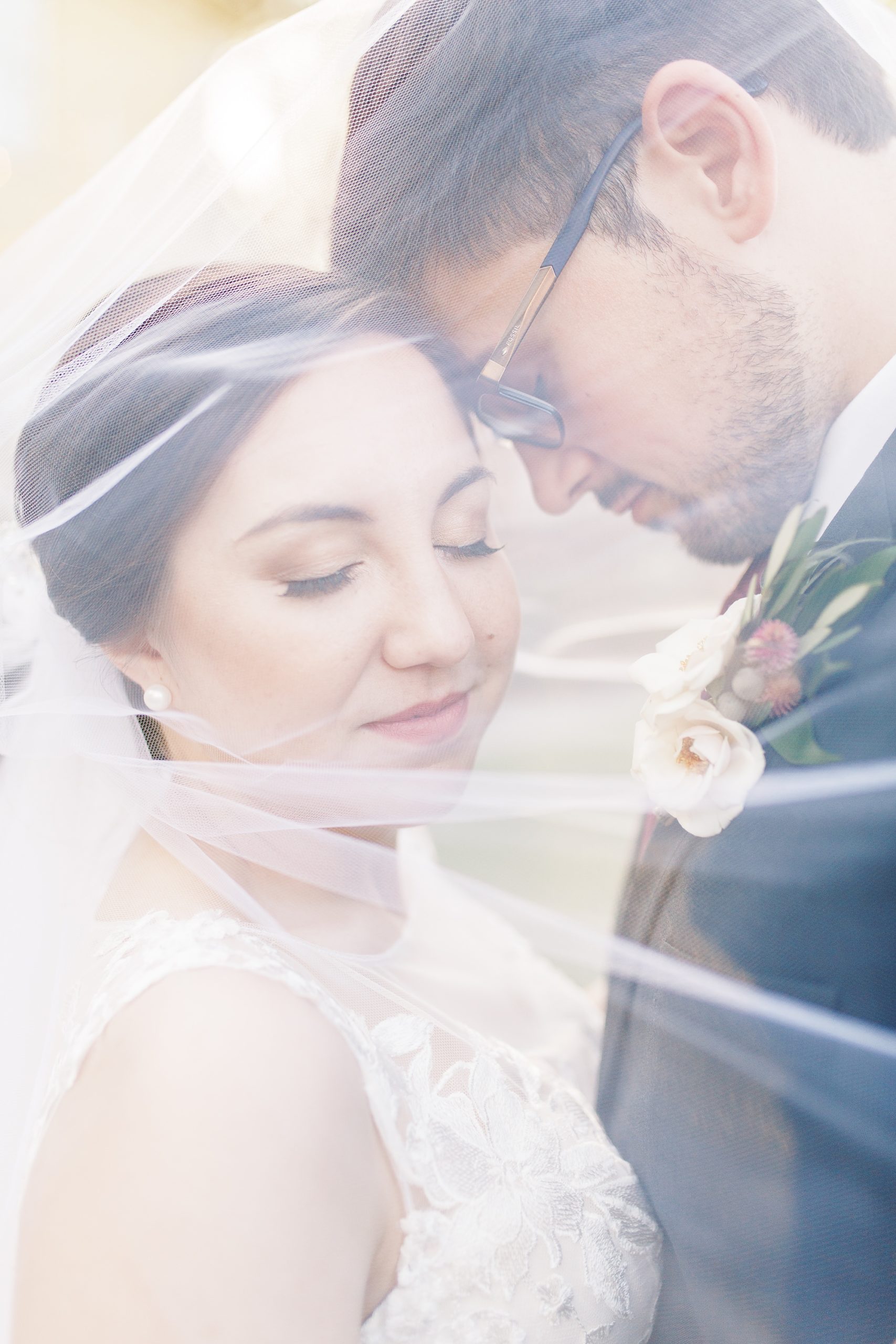 groom leans against brides forehead under veil