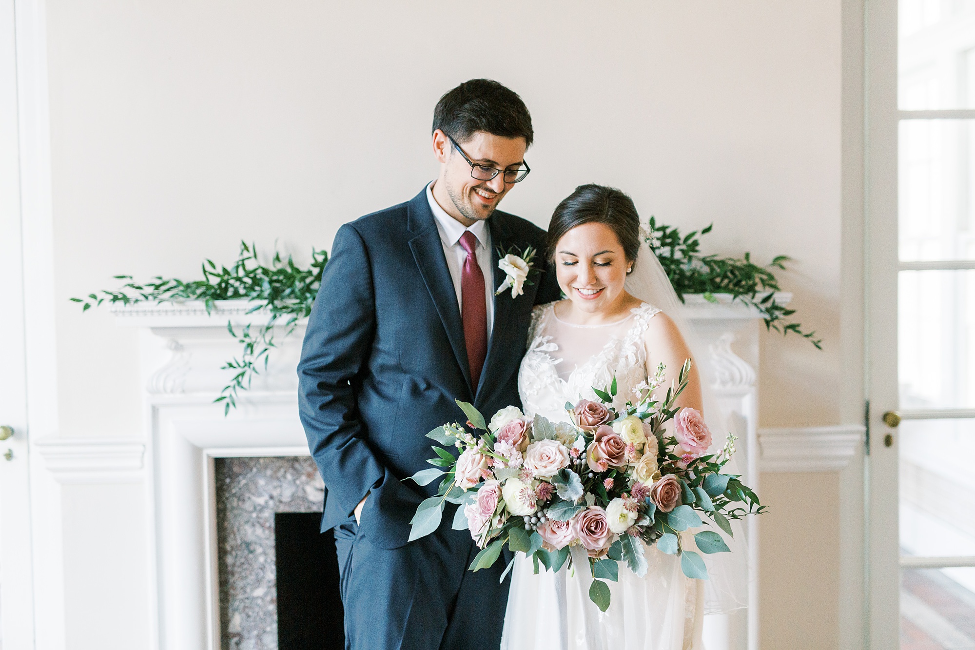 bride and groom pose in front of fireplace at Separk Mansion with mauve fall wedding bouquet