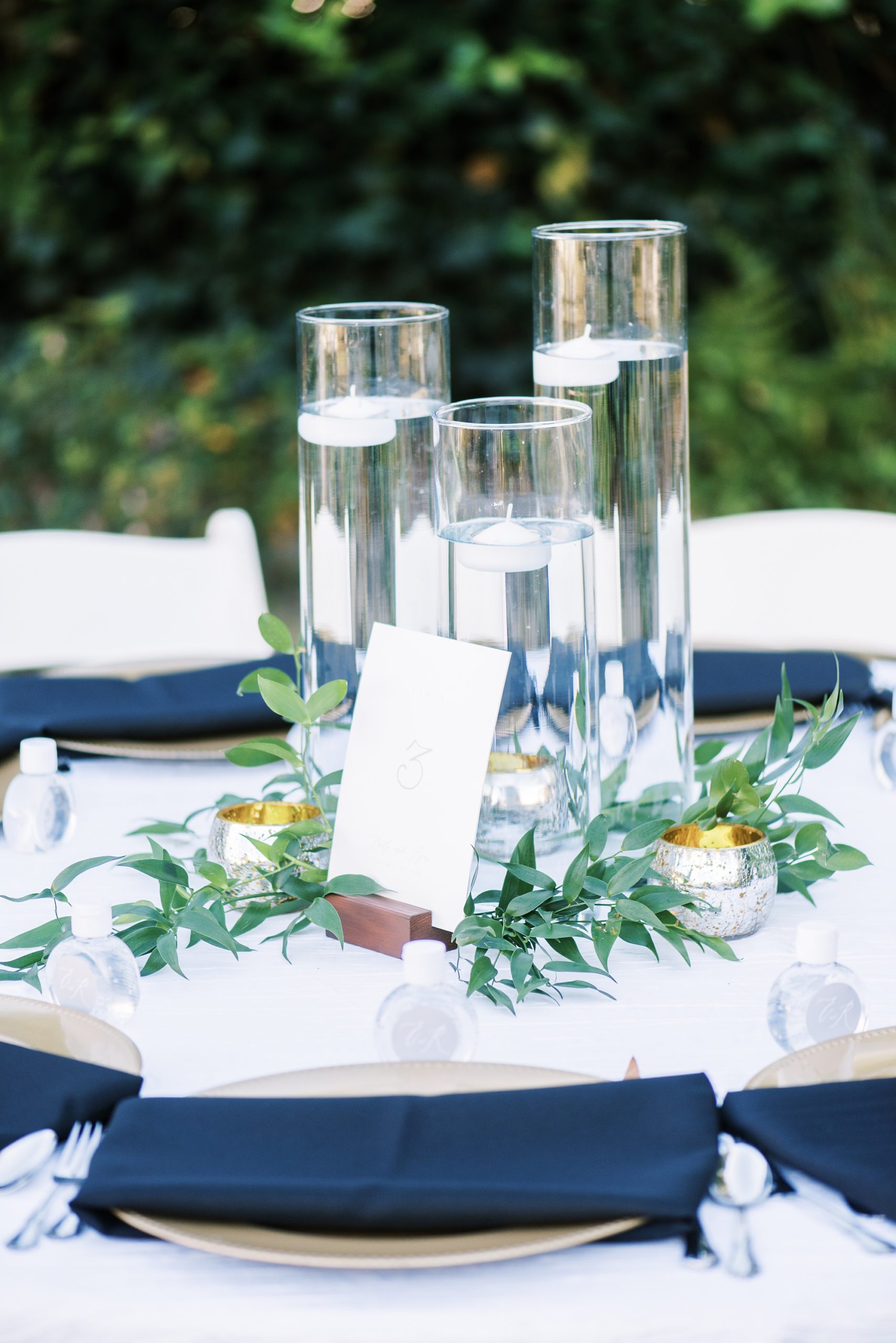 centerpieces with floating candles and greenery
