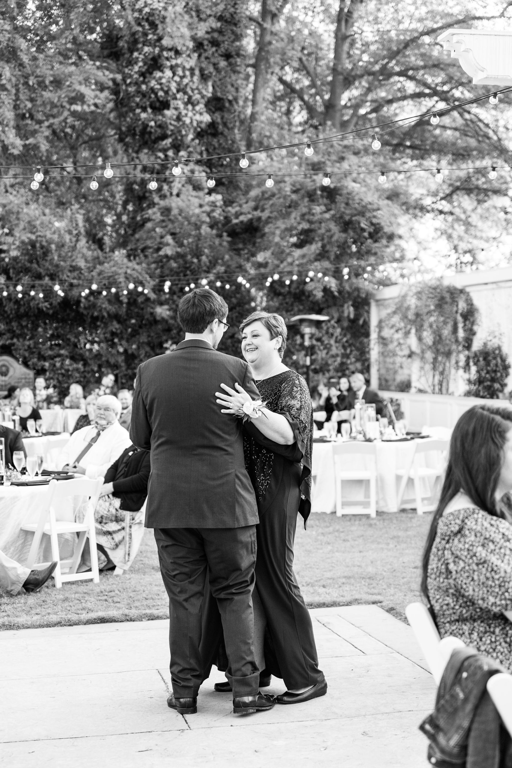 groom dances with mother during outdoor reception at Separk Mansion