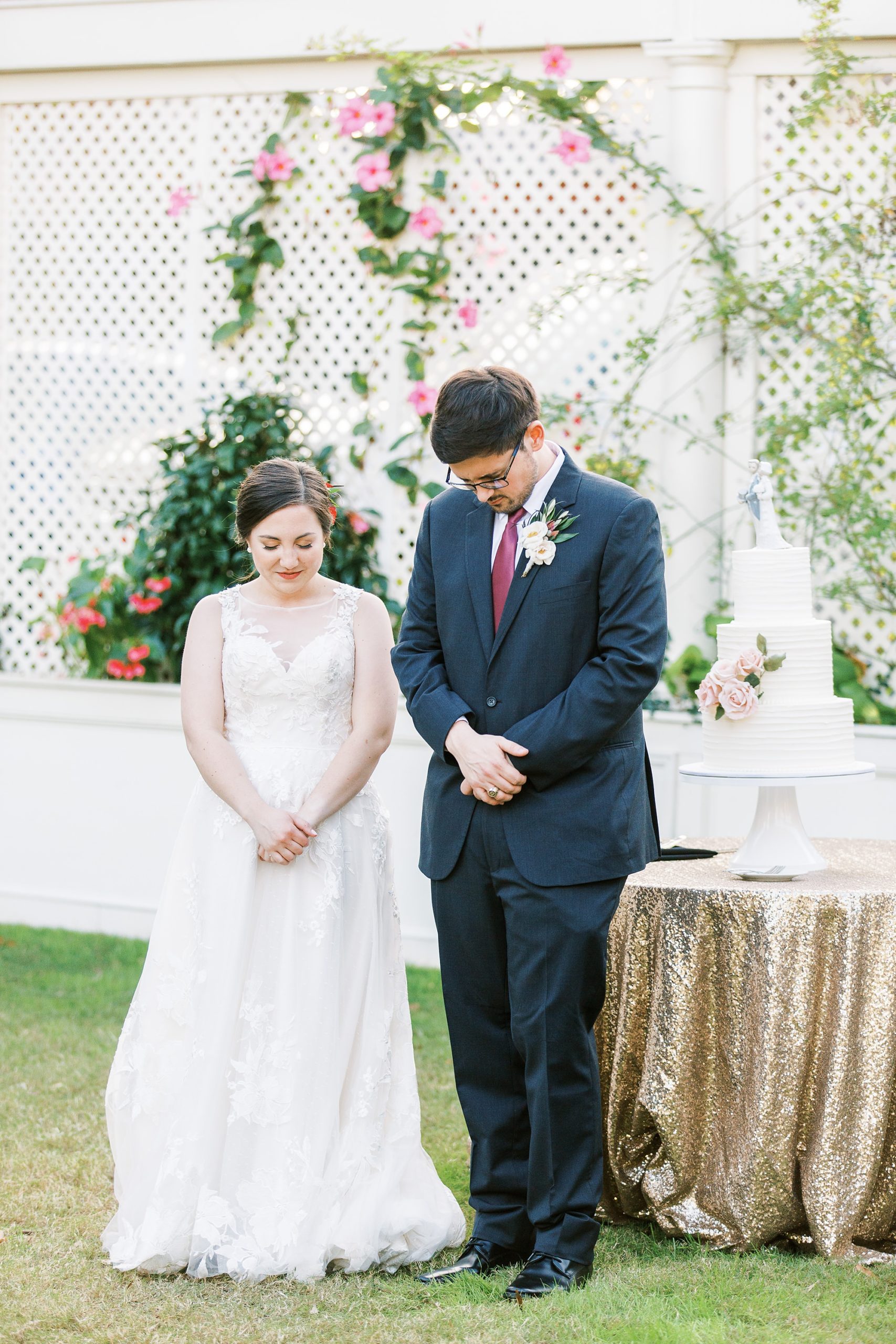 newlyweds pray during outdoor reception at Separk Mansion