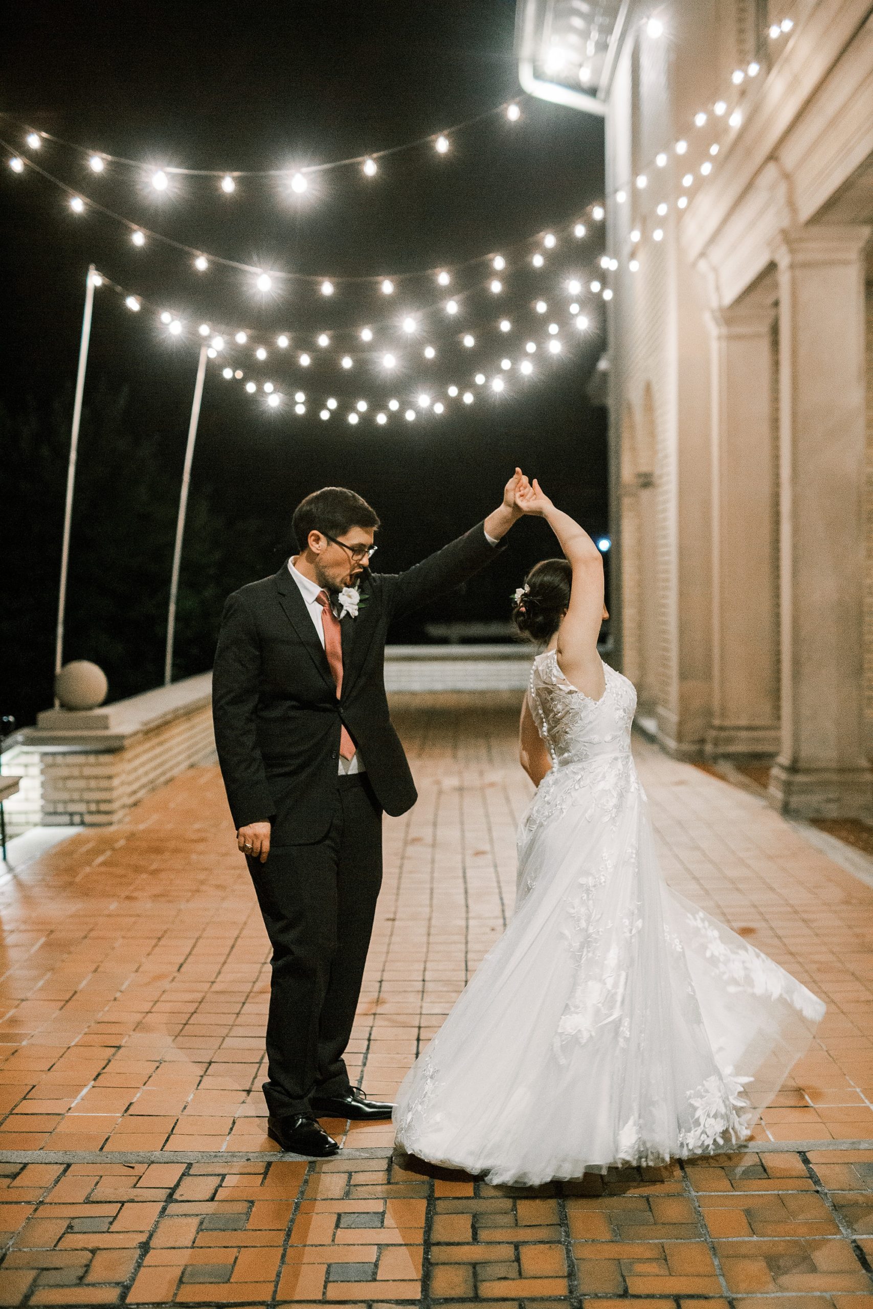 bride and groom dance on patio at Separk Mansion under lights
