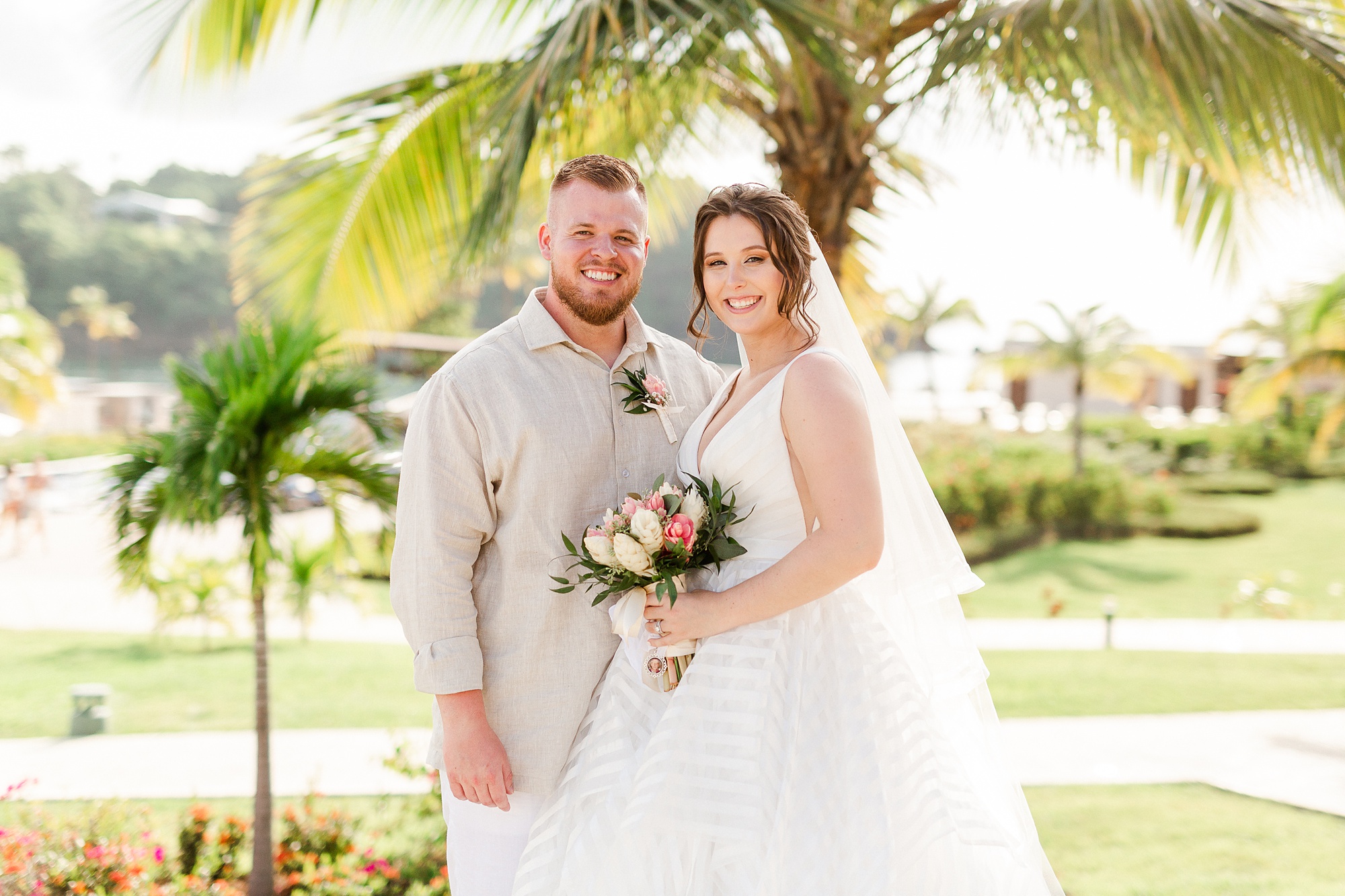 newlyweds pose by palm tree at Royalton Resort in St Lucia