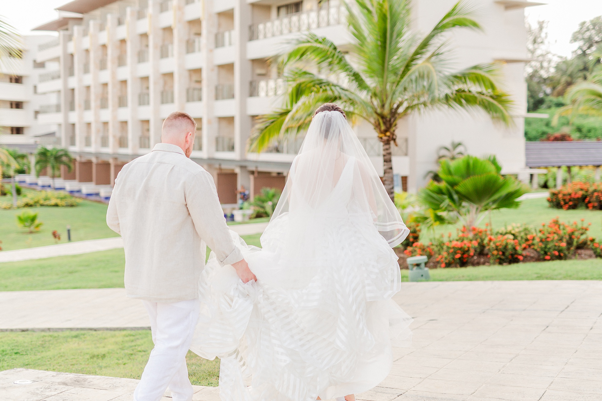 groom carries bride's skirt around Royalton Resort
