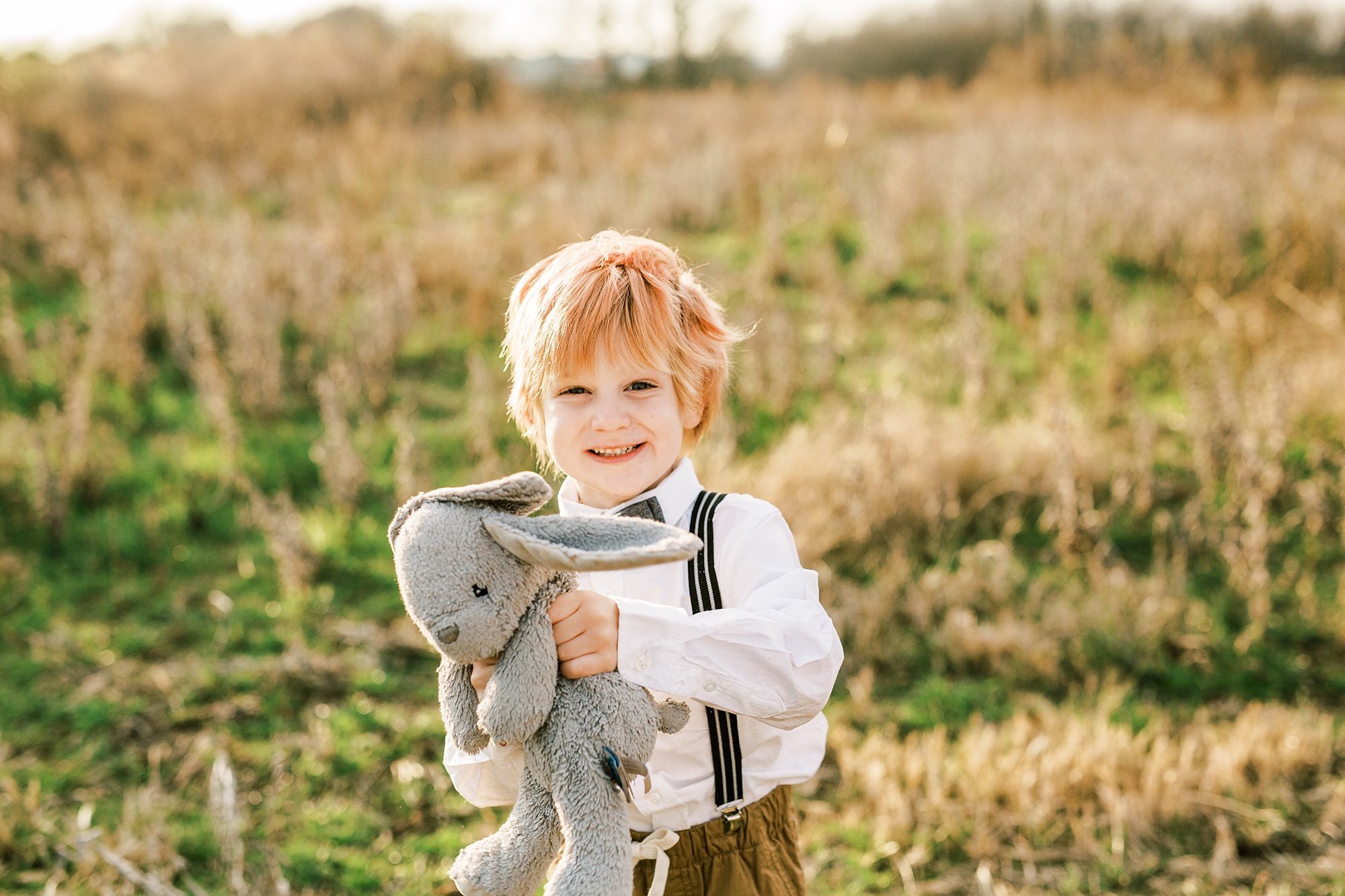 toddler holds stuffed bear during family photos