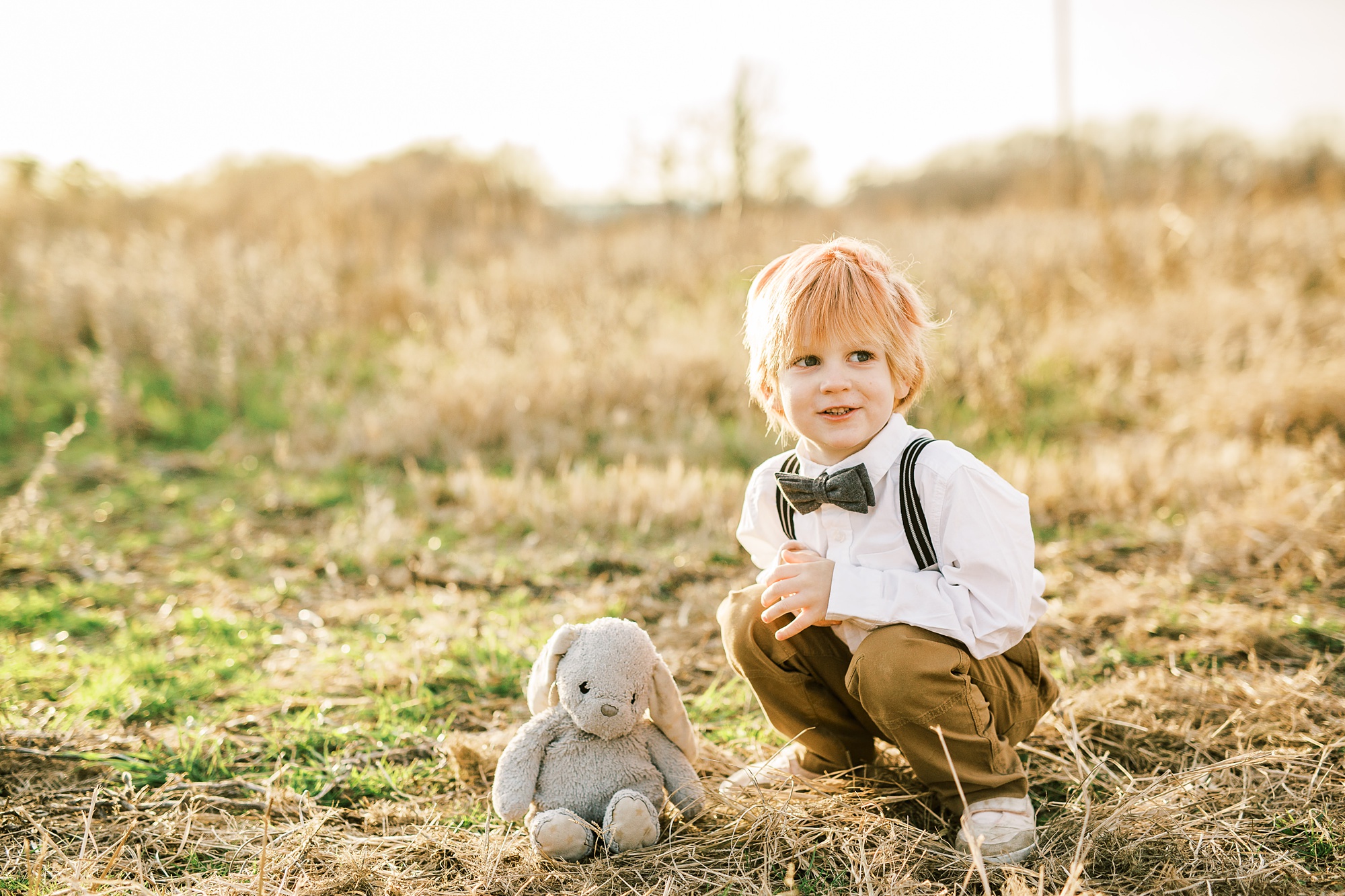toddler plays with stuffed bunny during family photos