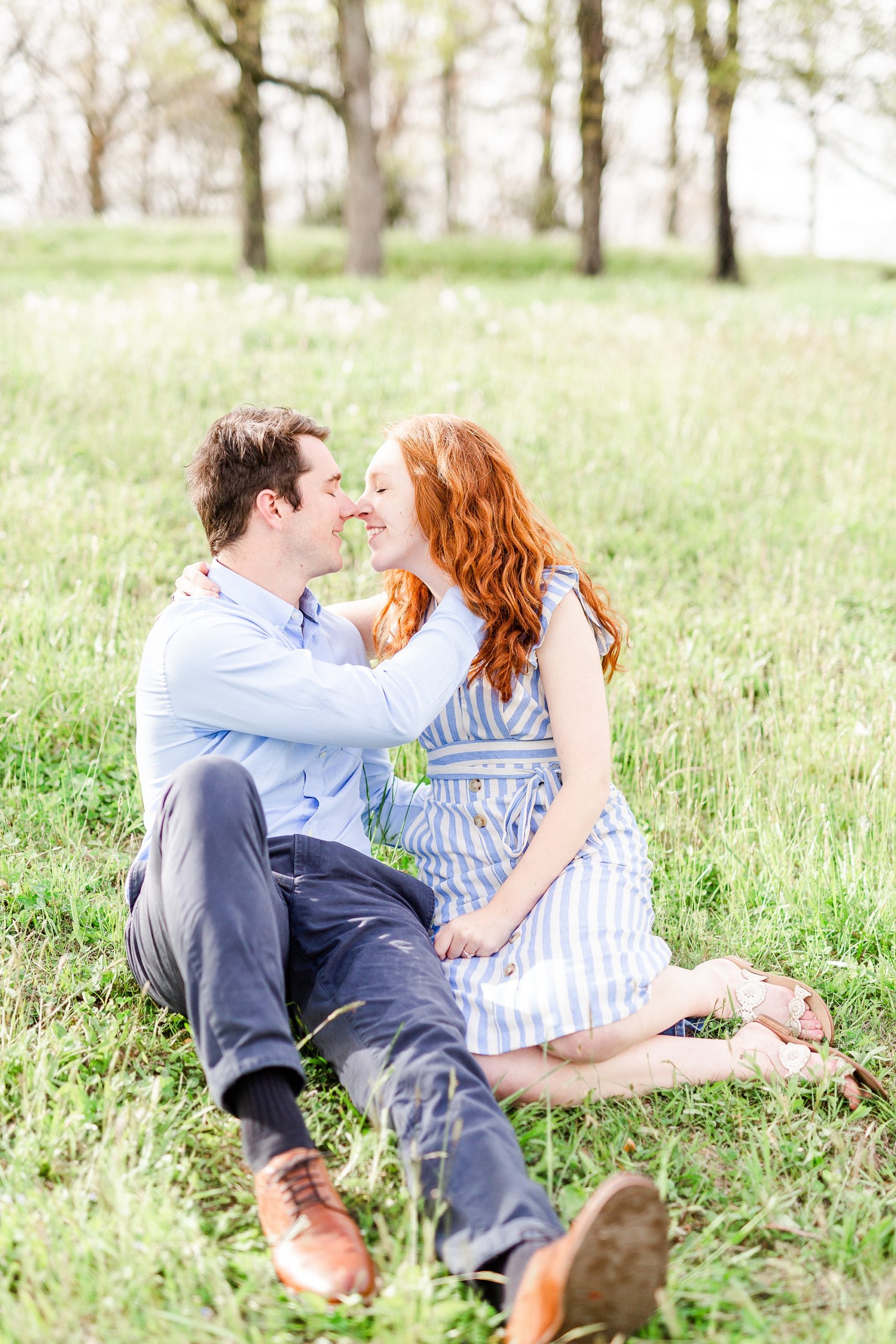 engaged couple sits touching noses during Boone NC spring engagement photos