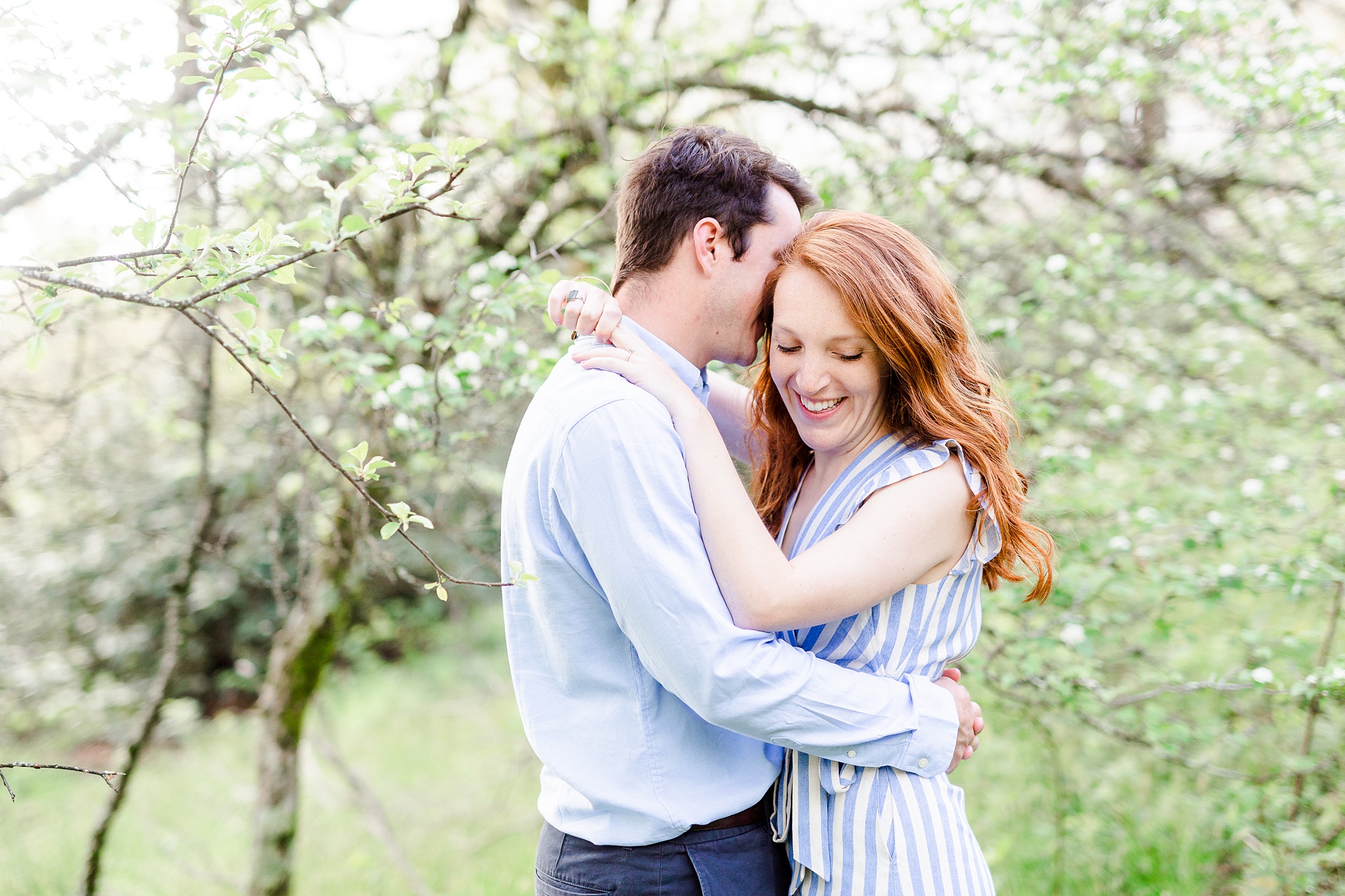 groom whispers in bride's ear during Thunderhill Overlook engagement photos