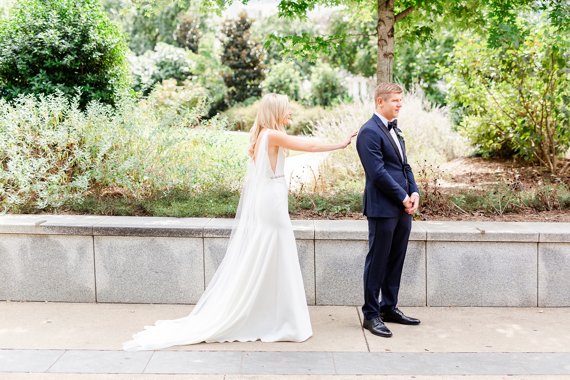 bride approaches groom during first look at Romare Bearden Park