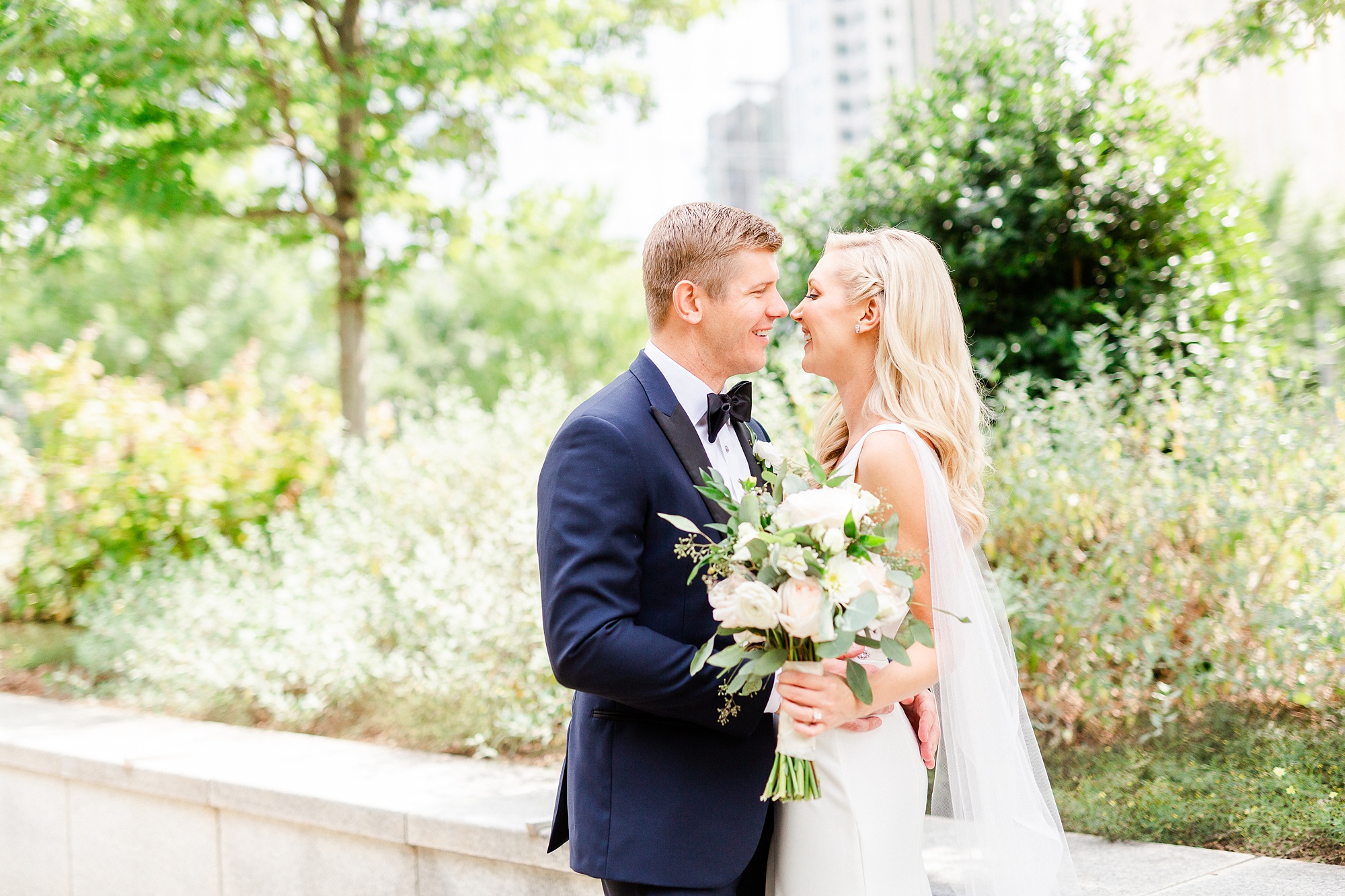 bride and groom kiss during portraits at Romare Bearden Park