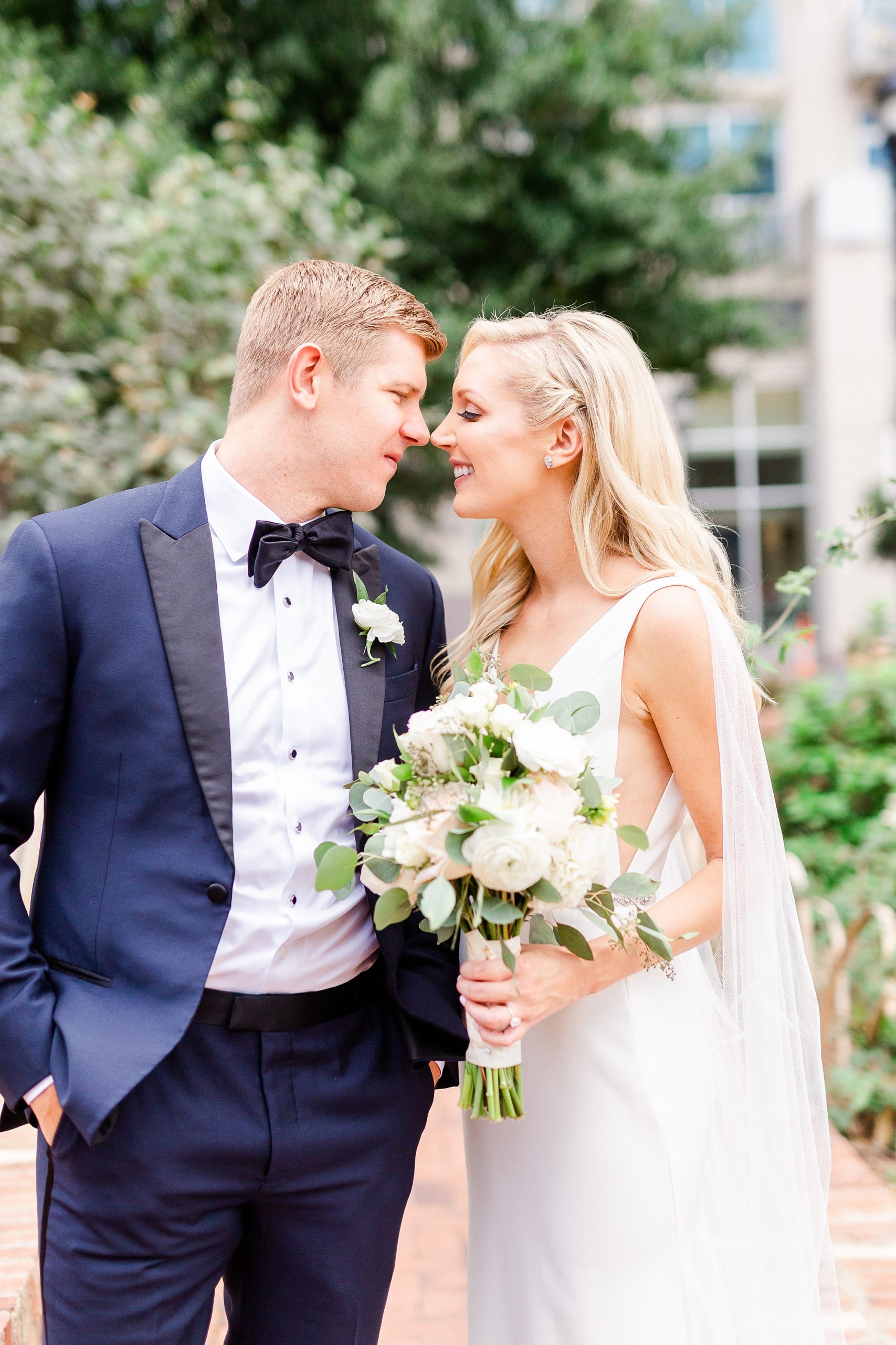 bride and groom stand nose to nose during Romare Bearden Park wedding photos
