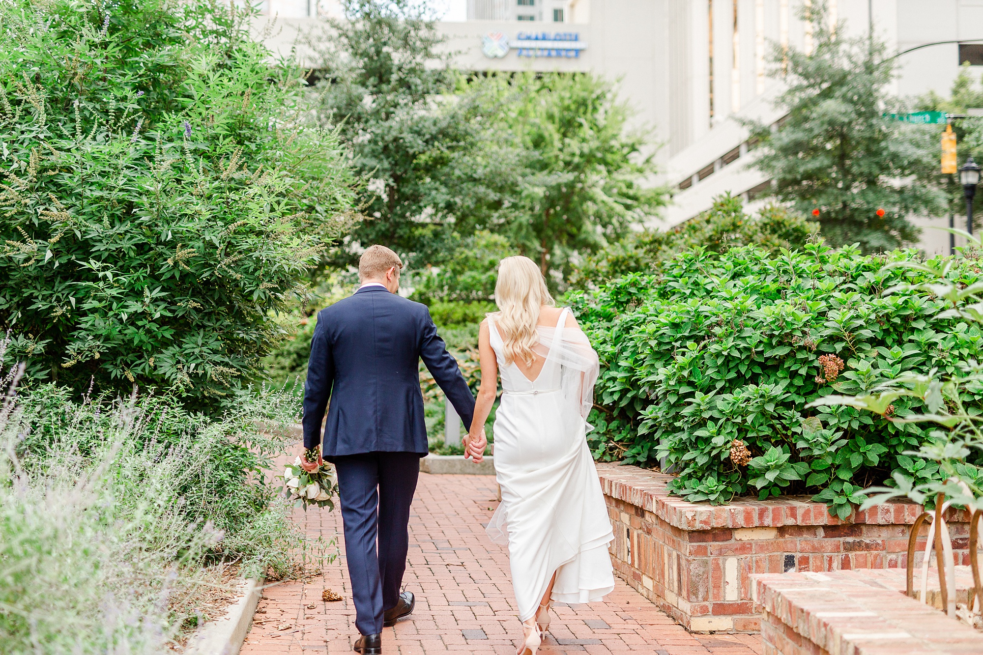 newlyweds walk through Romare Bearden Park