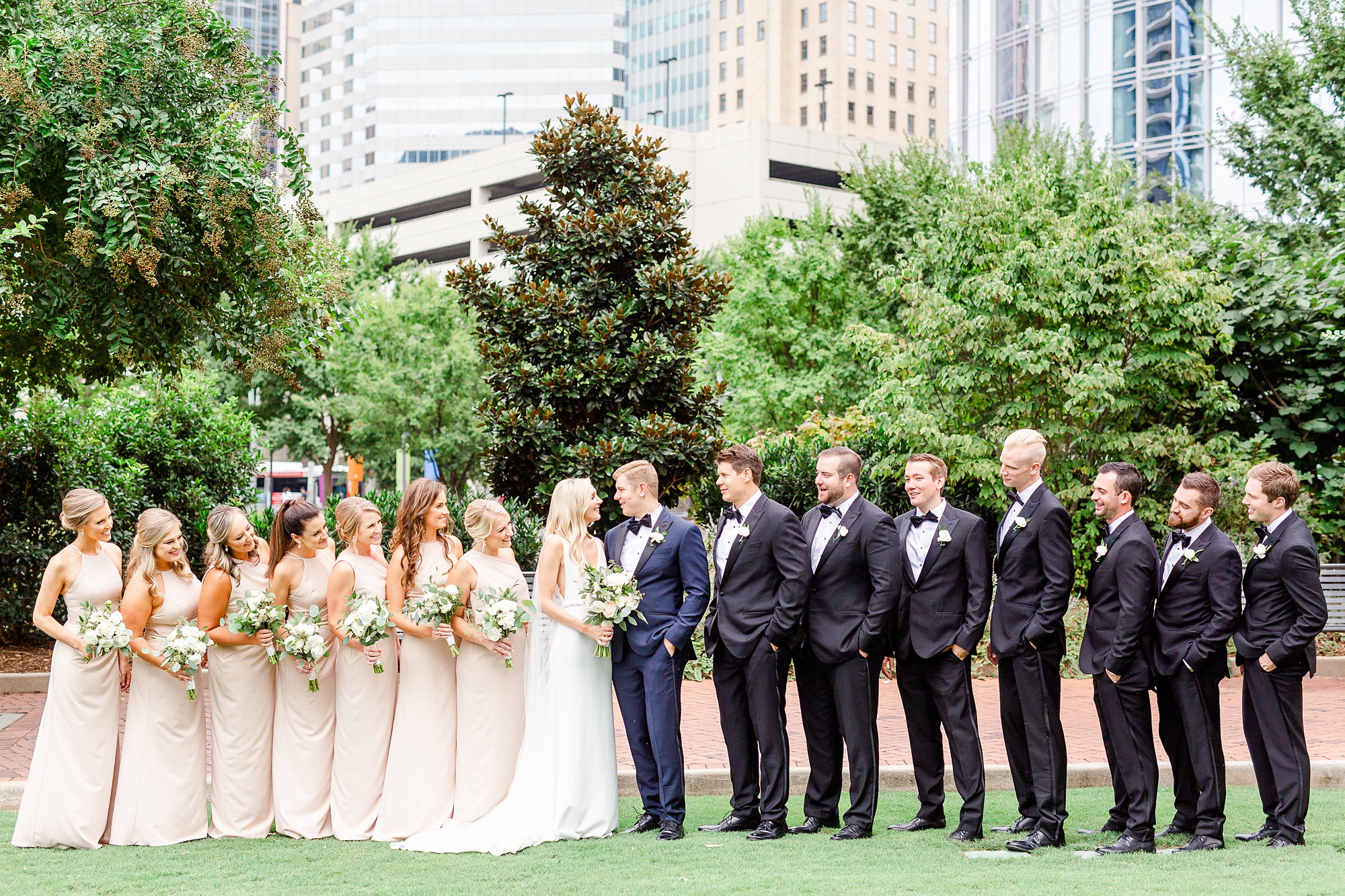 wedding party in tuxes and champagne gowns pose in Romare Bearden Park