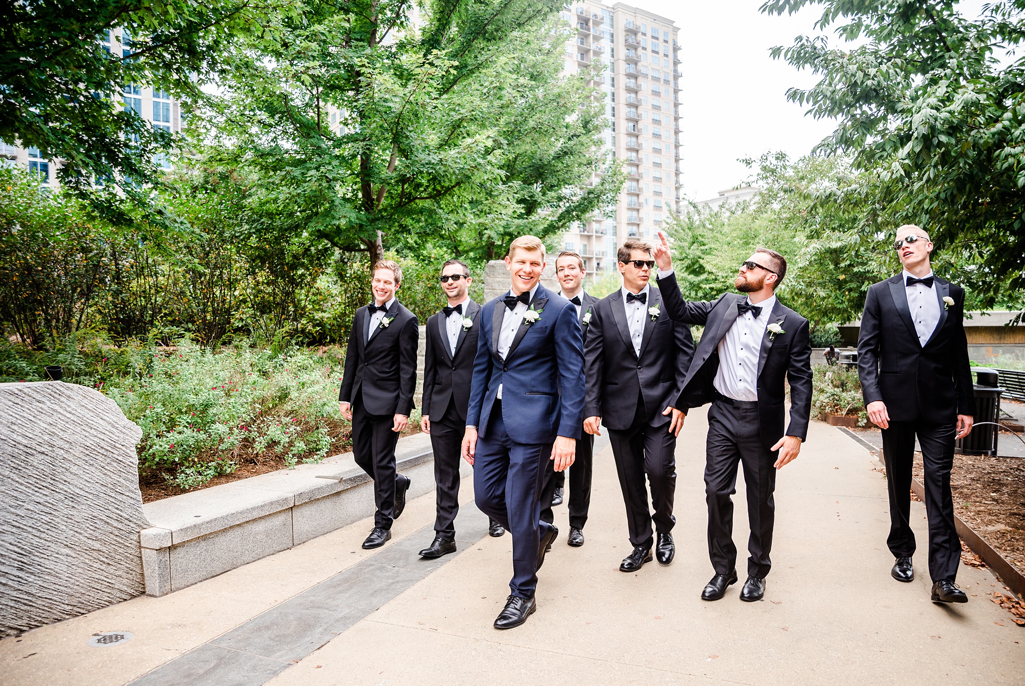groom and groomsmen walk through Romare Bearden Park