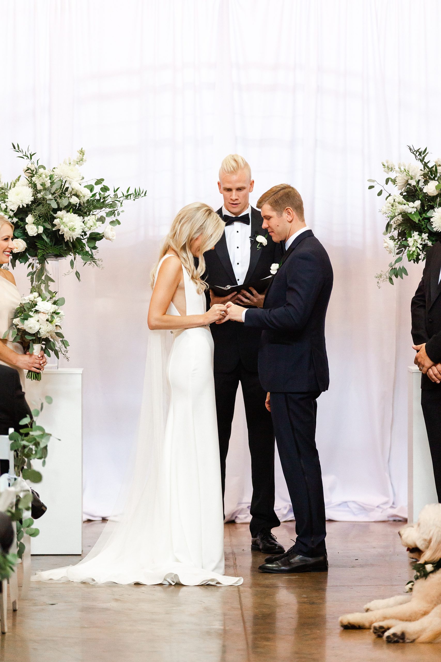 bride and groom exchange rings during Design Center Atrium ceremony