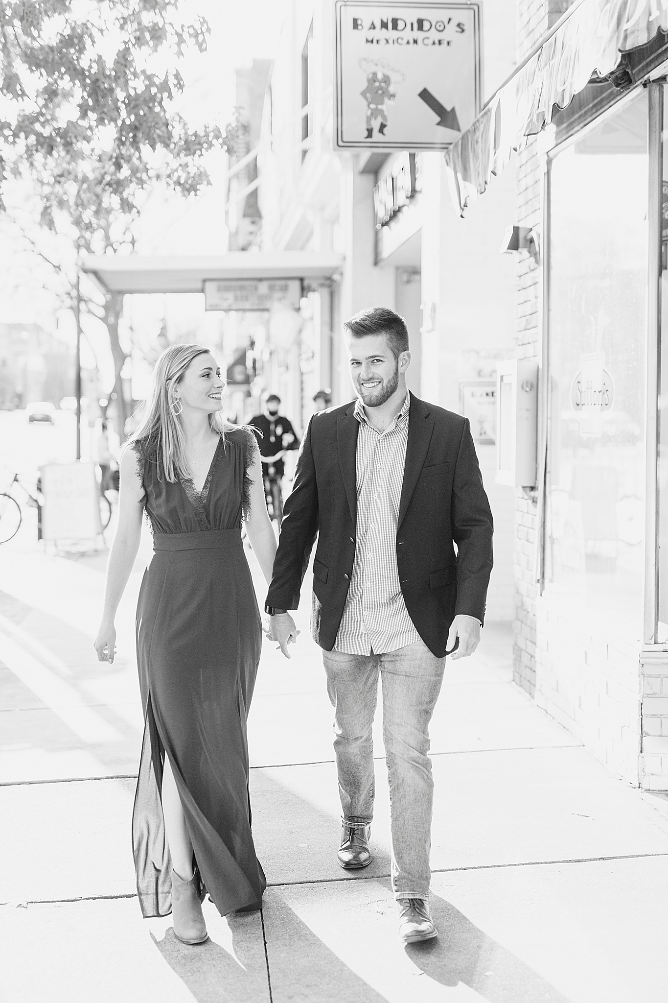 couple laughs walking in Chapel Hill during engagement photos