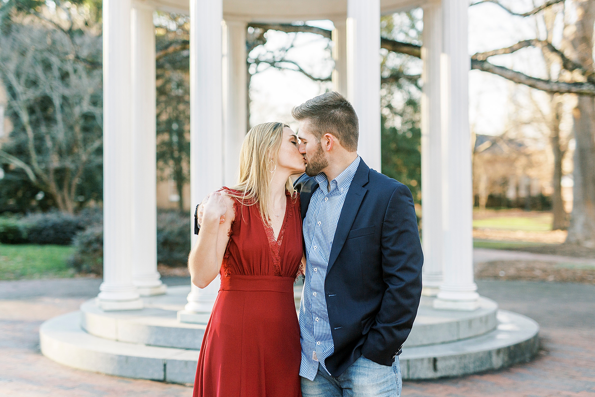 engaged couple kisses in front of Chapel Hill gazebo