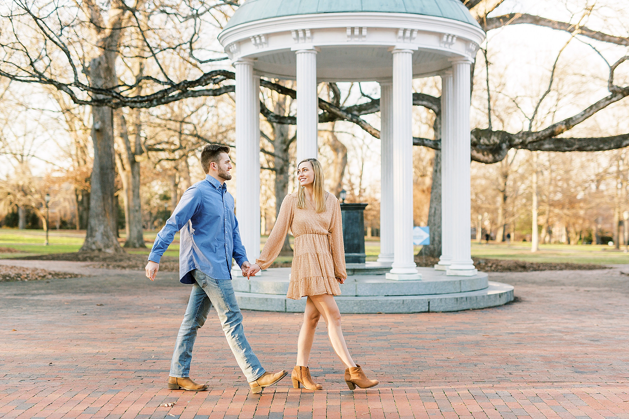 engaged couple walks by rotunda at Chapel Hill