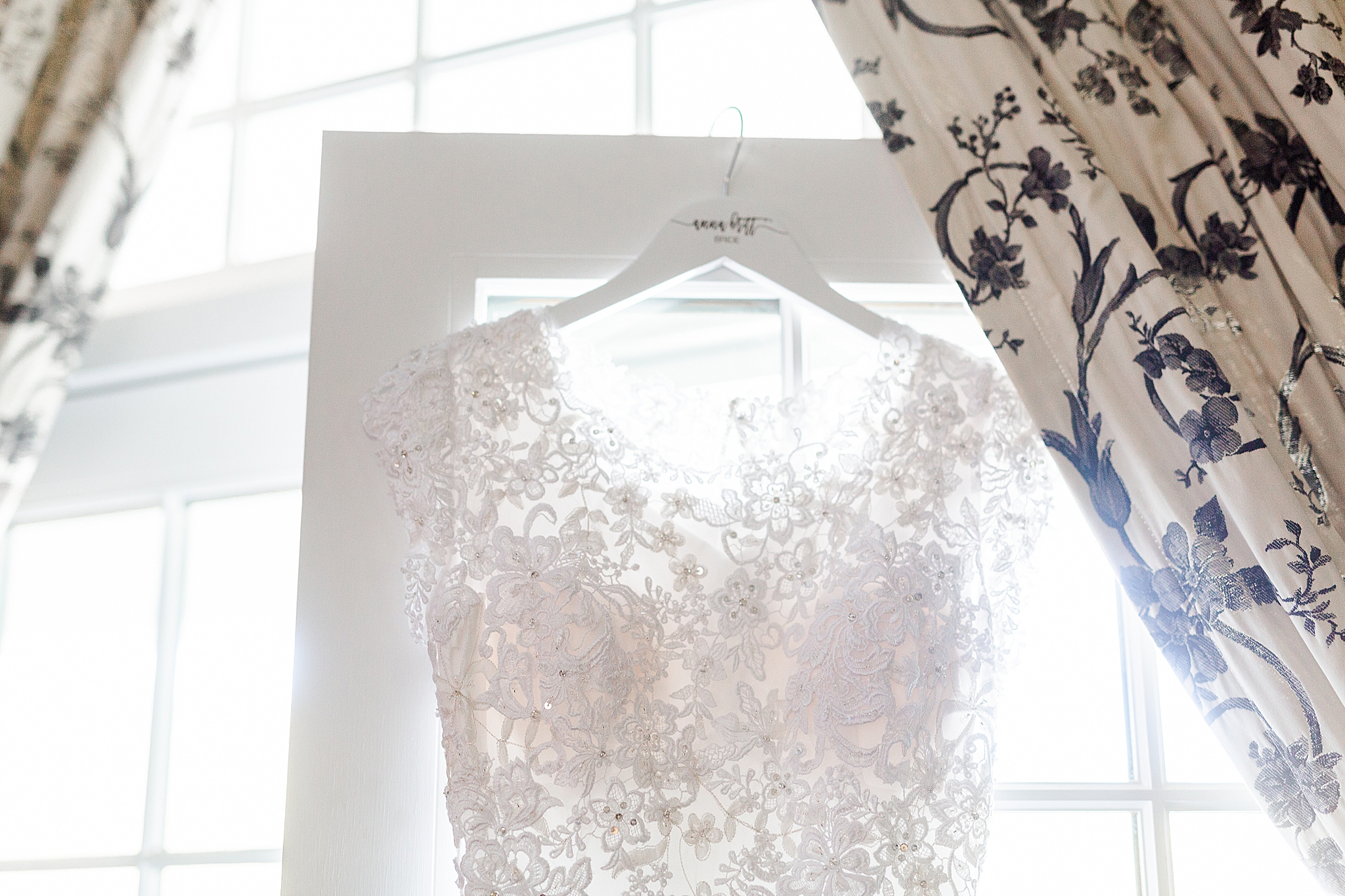 classic wedding gown hangs in window